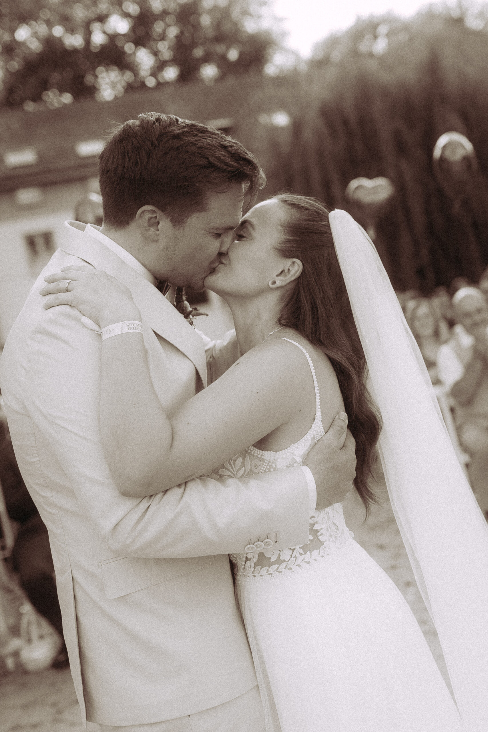 Brautpaar küsst sich liebevoll bei der Hochzeit am Haus Heinz am See.