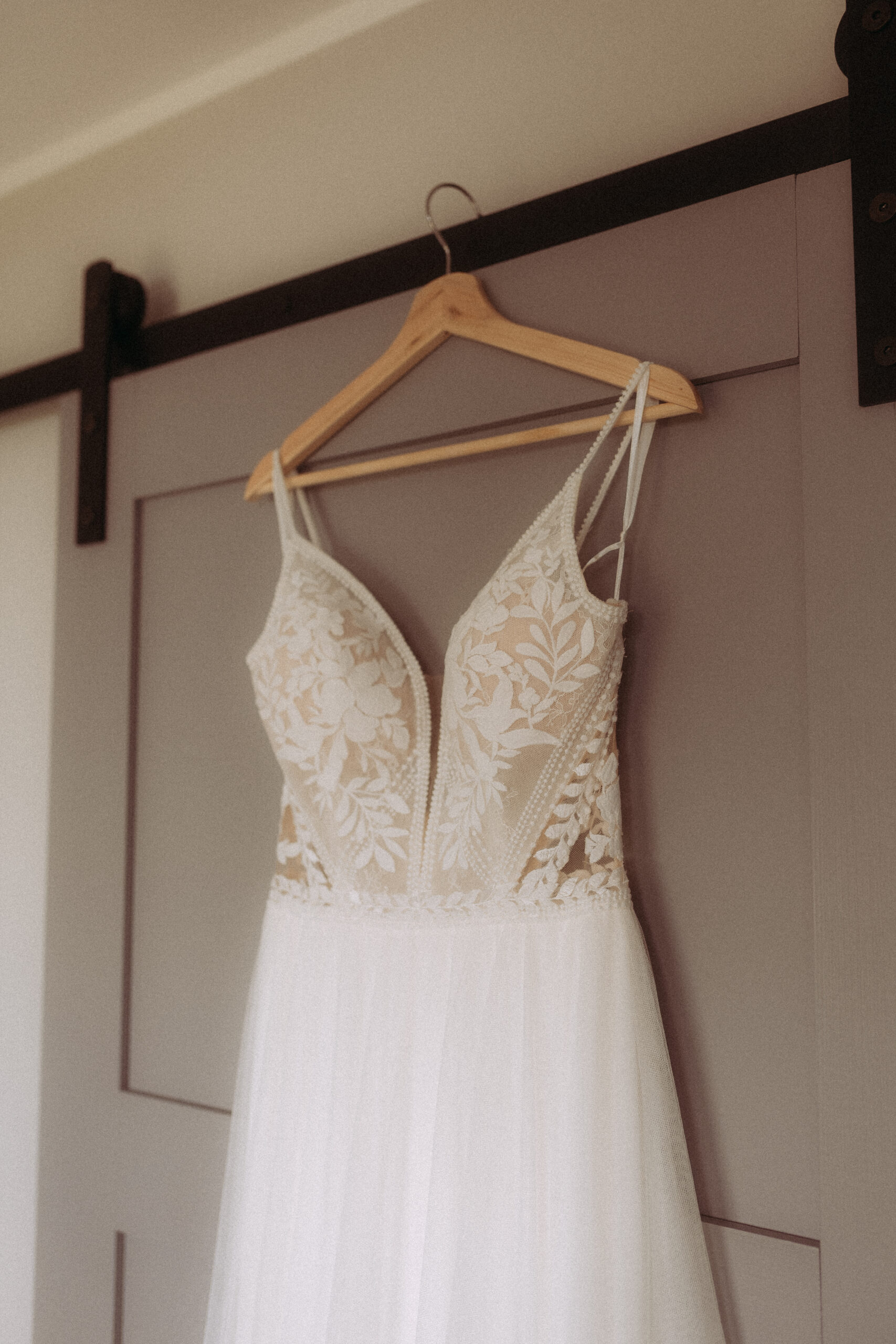 Brautkleid hängt an Holztür, Destination Weddings