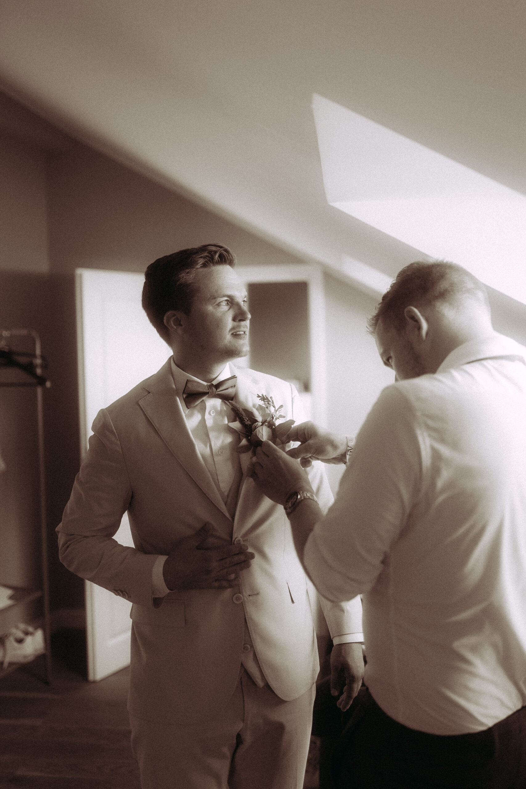 Bräutigam bekommt Anstecker am Haus Heinz am See, Hochzeit