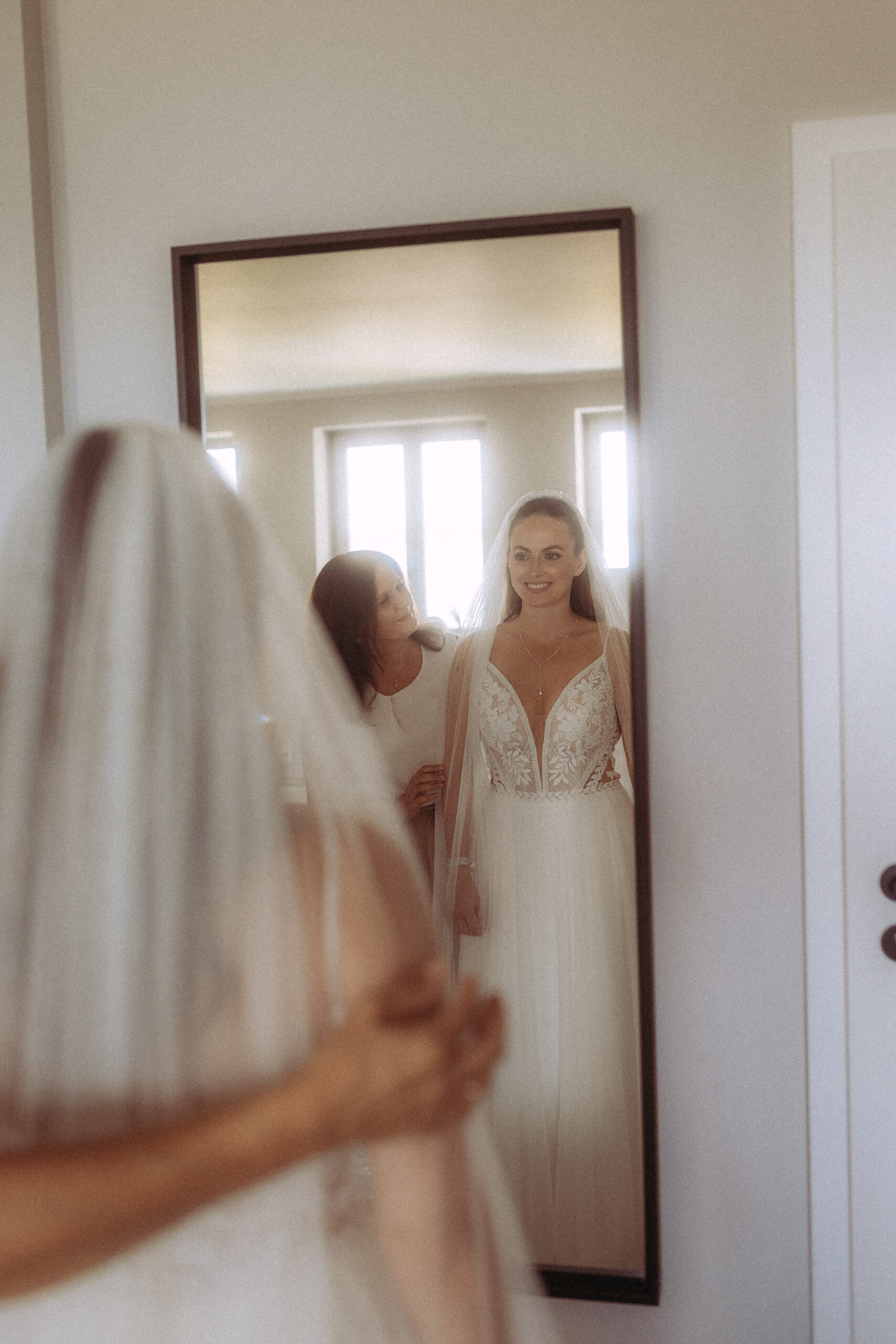 Braut im Spiegel mit Mutter, Hochzeitskleid. Vorbereitungen für die Hochzeit