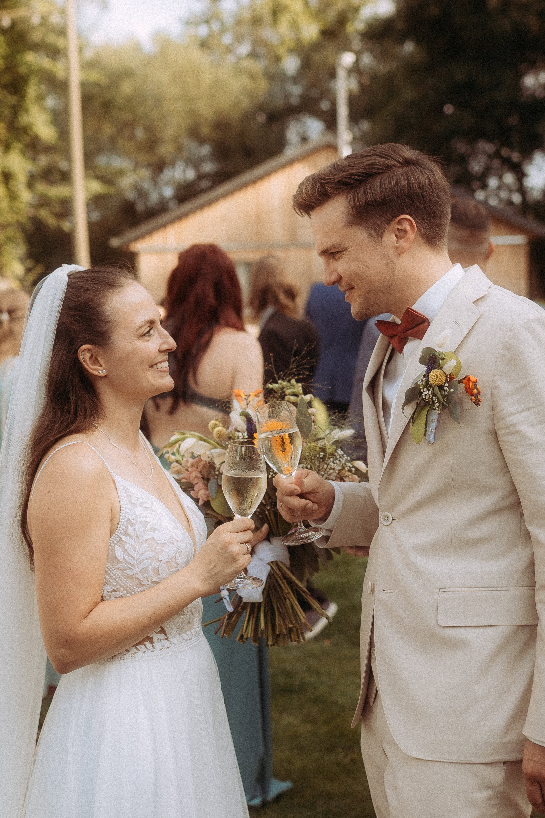 Brautpaar stößt mit Sekt auf einer Hochzeit im Freien an