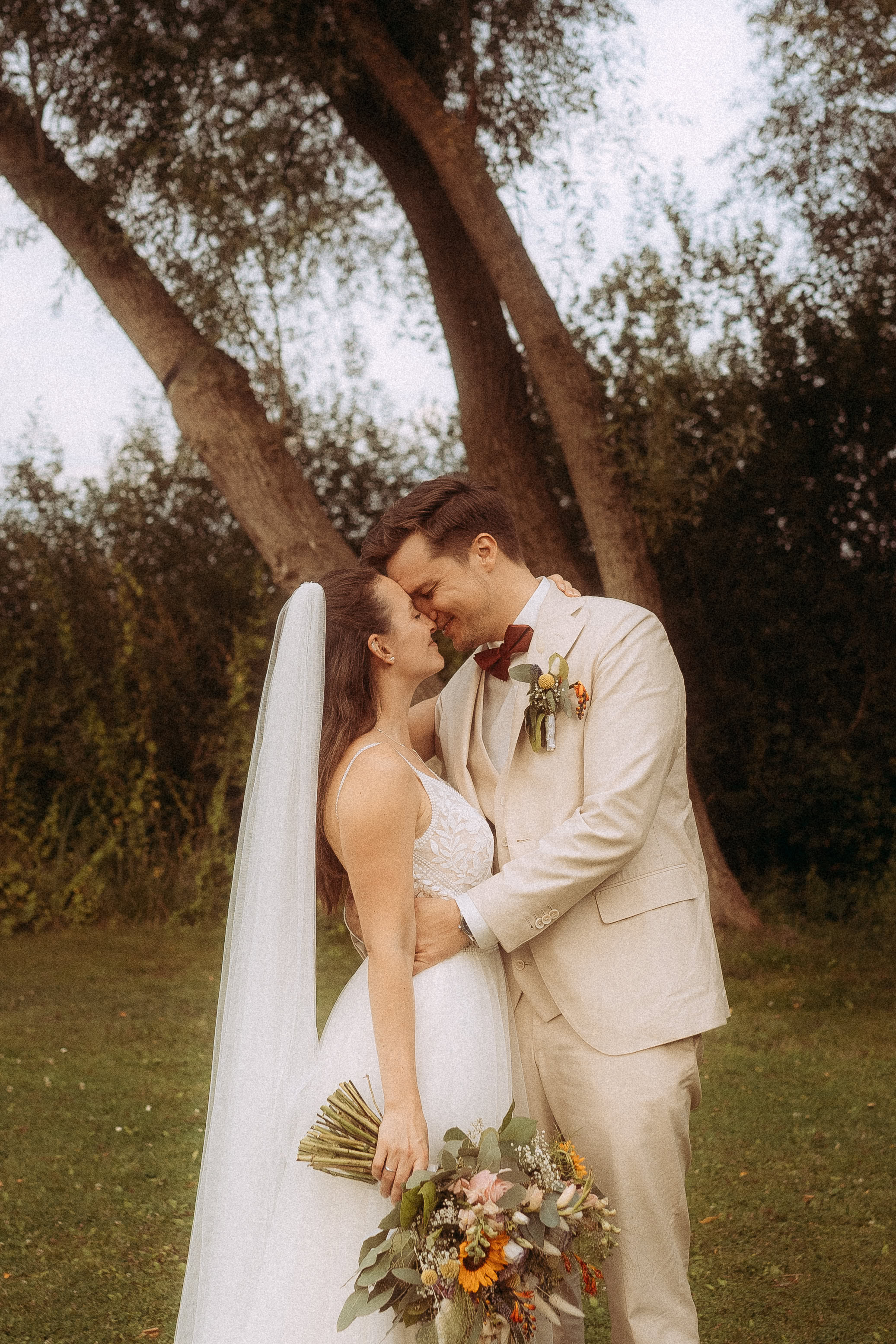 Brautpaar küsst sich zärtlich am Haus Heinz am See, die Hochzeit feiernd.