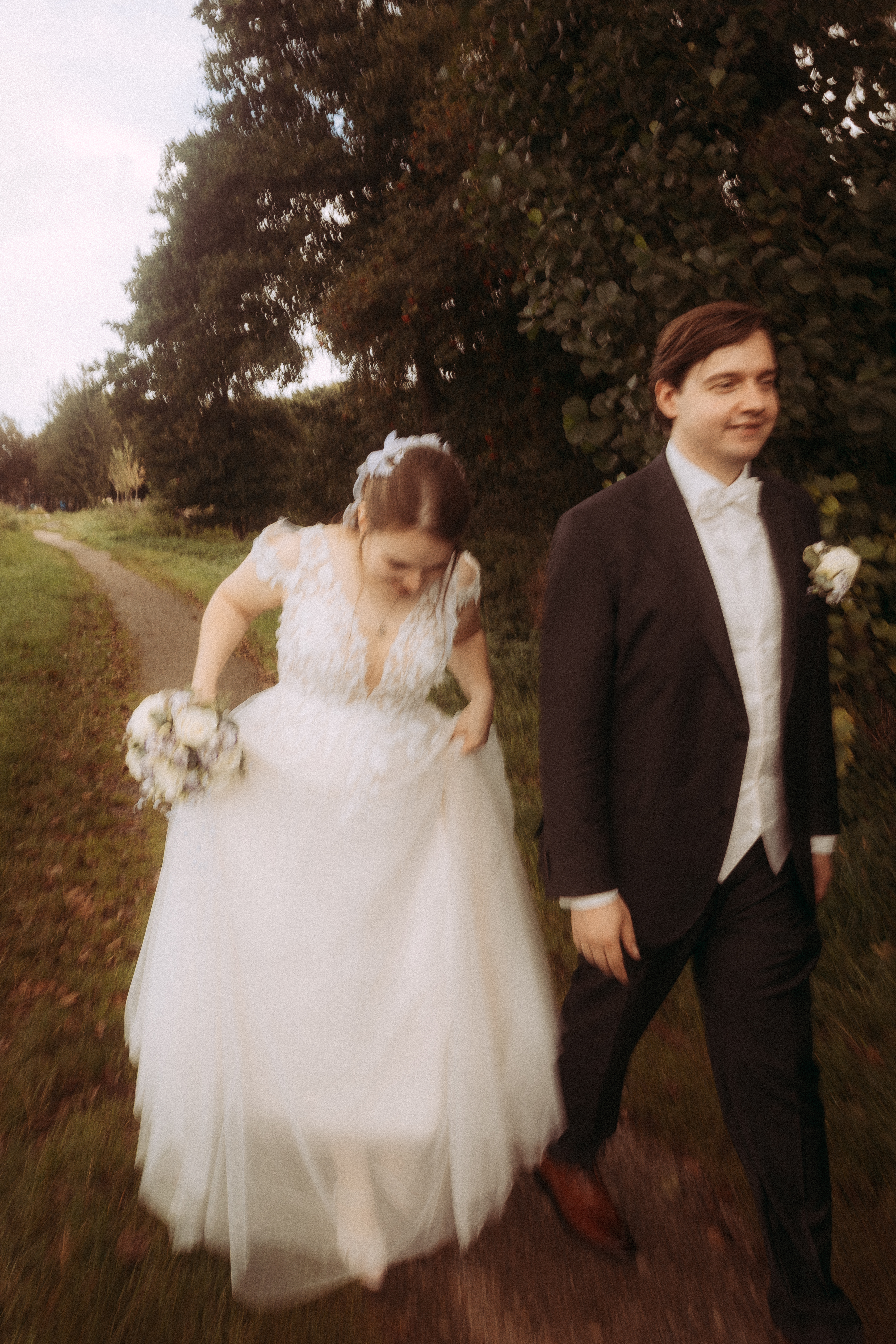 Brautpaar bei der standesamtlichen Hochzeit in Friedland (MV) geht auf einem Weg entlang.