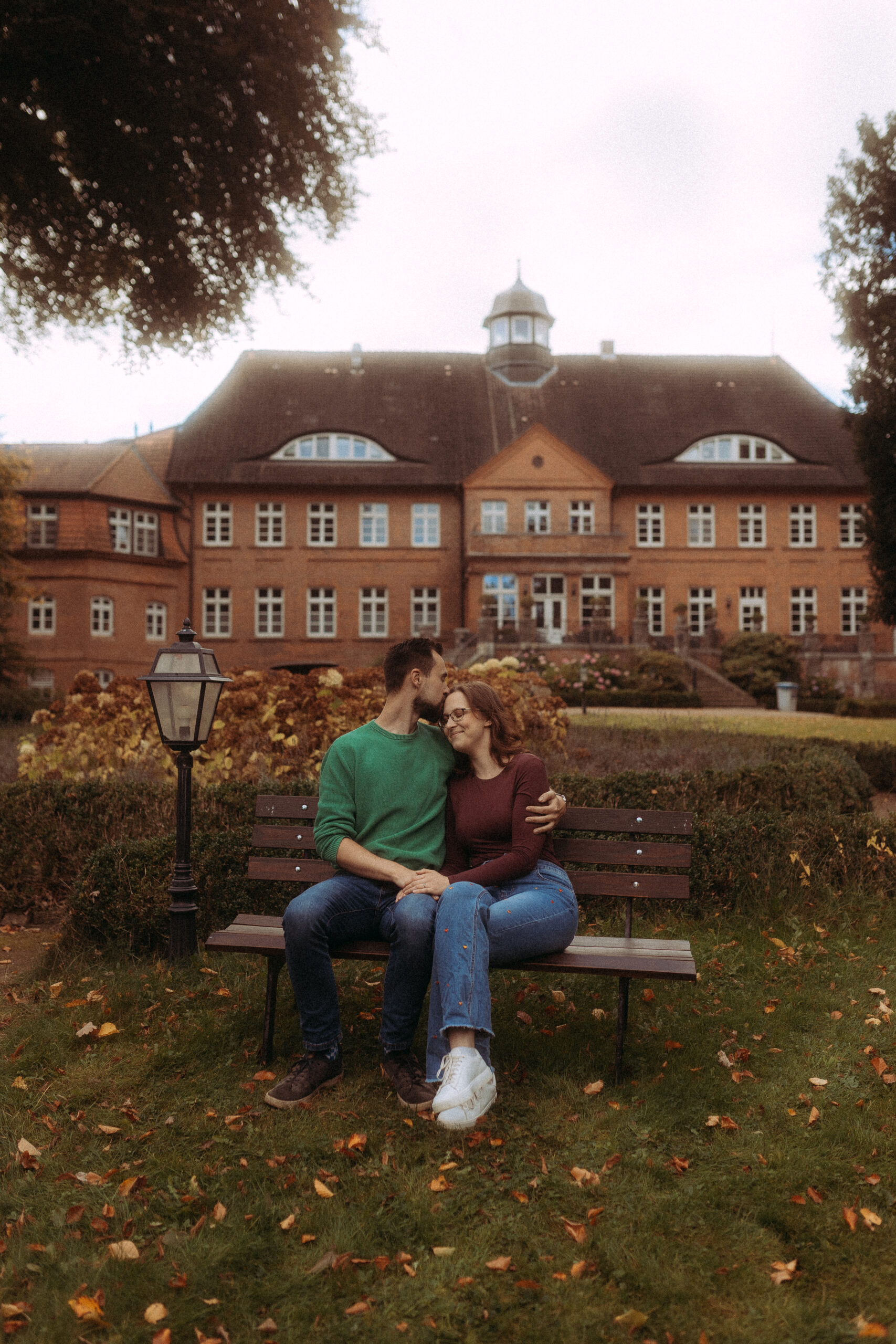 Verliebtes Paar sitzt auf Bank vor Schloss, möglicherweise Hochzeitsshooting Melchsee Frutt