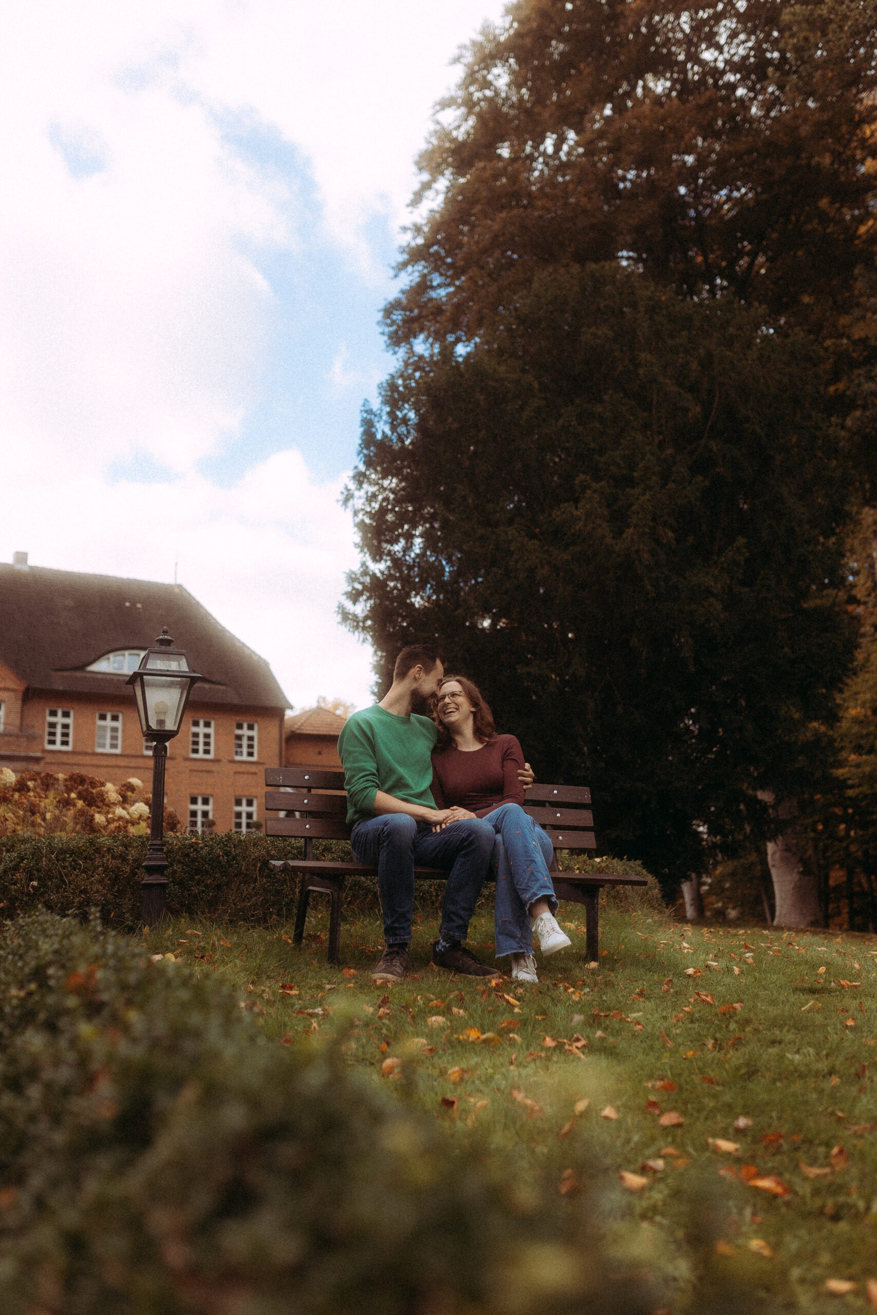 Pärchenfotos in Röbel: Glückliches Paar sitzt auf Bank im Park, verliebt