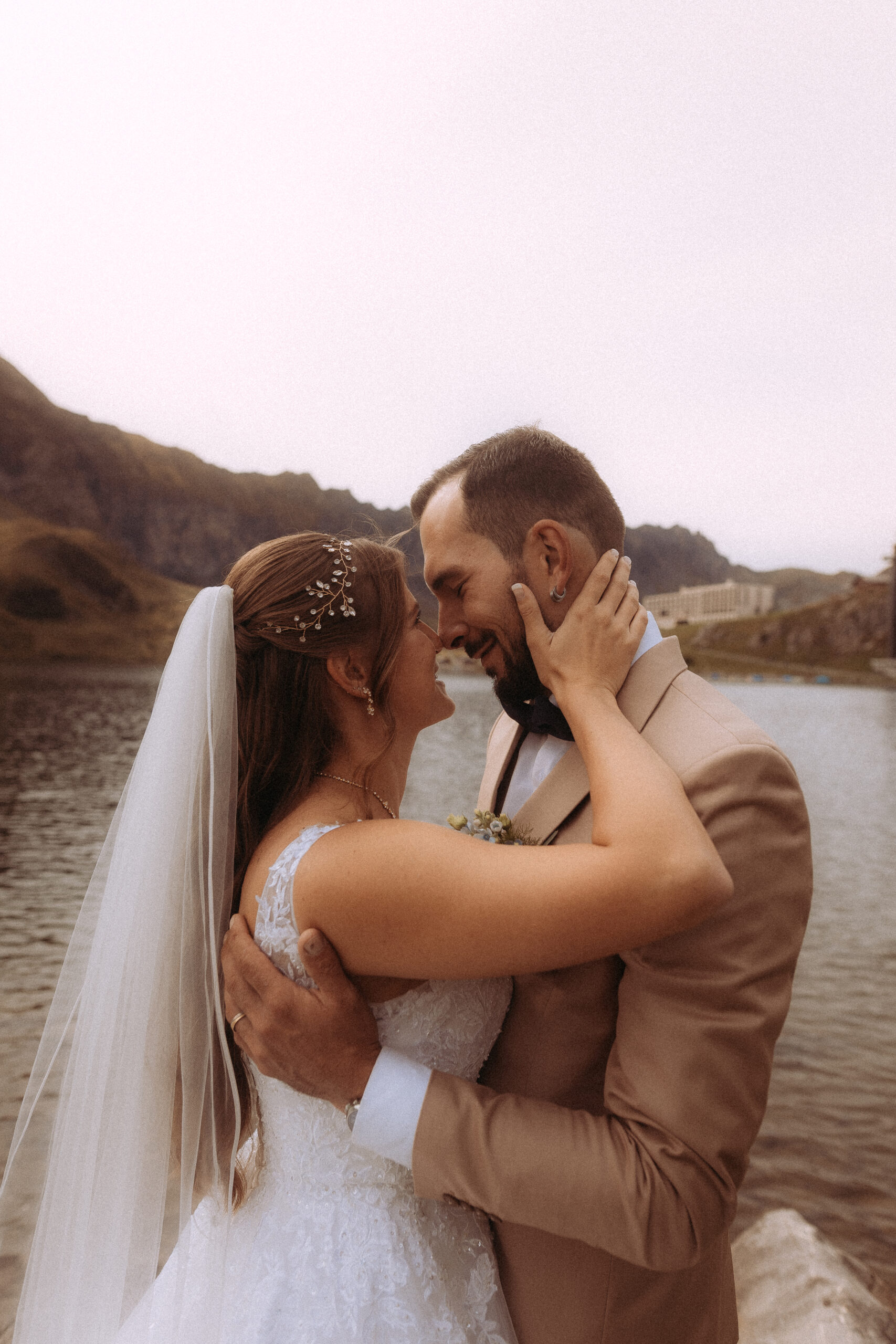 Brautpaar umarmt sich verliebt vor Bergsee bei Hochzeit Melchsee-Frutt Schweiz