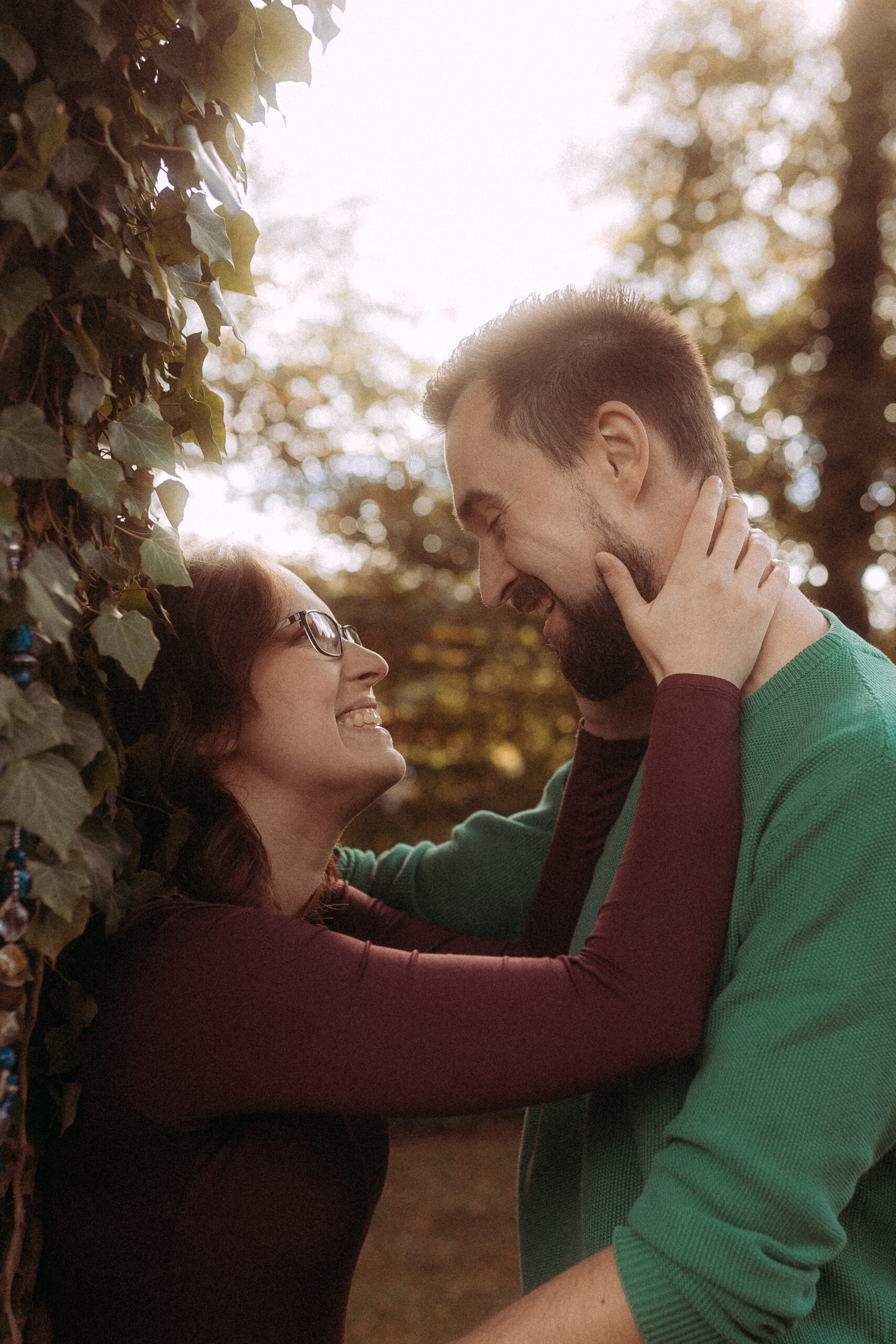 Pärchenshooting in Basthorst: Glückliches Paar umarmt sich innig unter Bäumen.