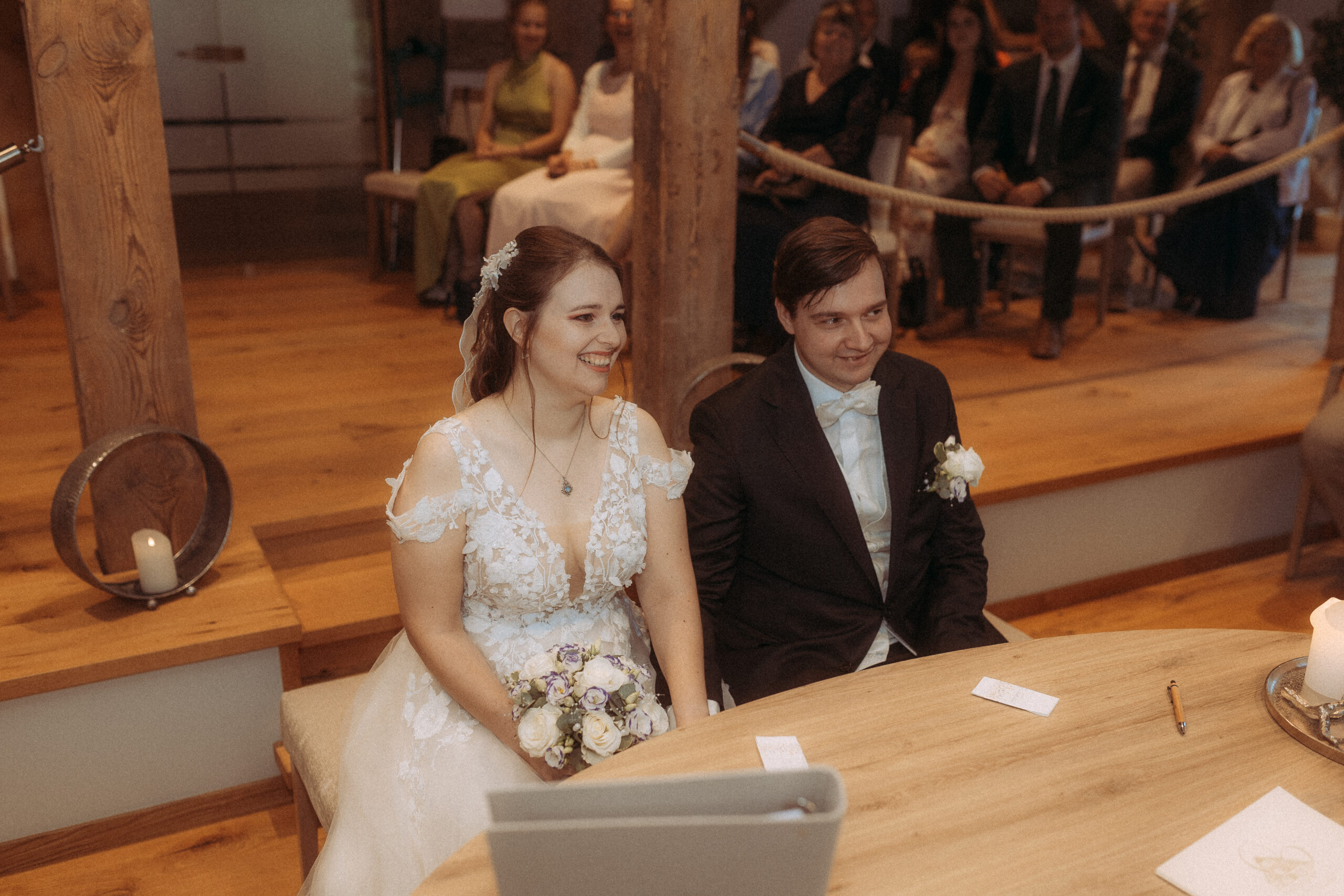 Brautpaar bei standesamtlicher Hochzeit in Friedland (MV) am Tisch. Glückliche Gesichter.