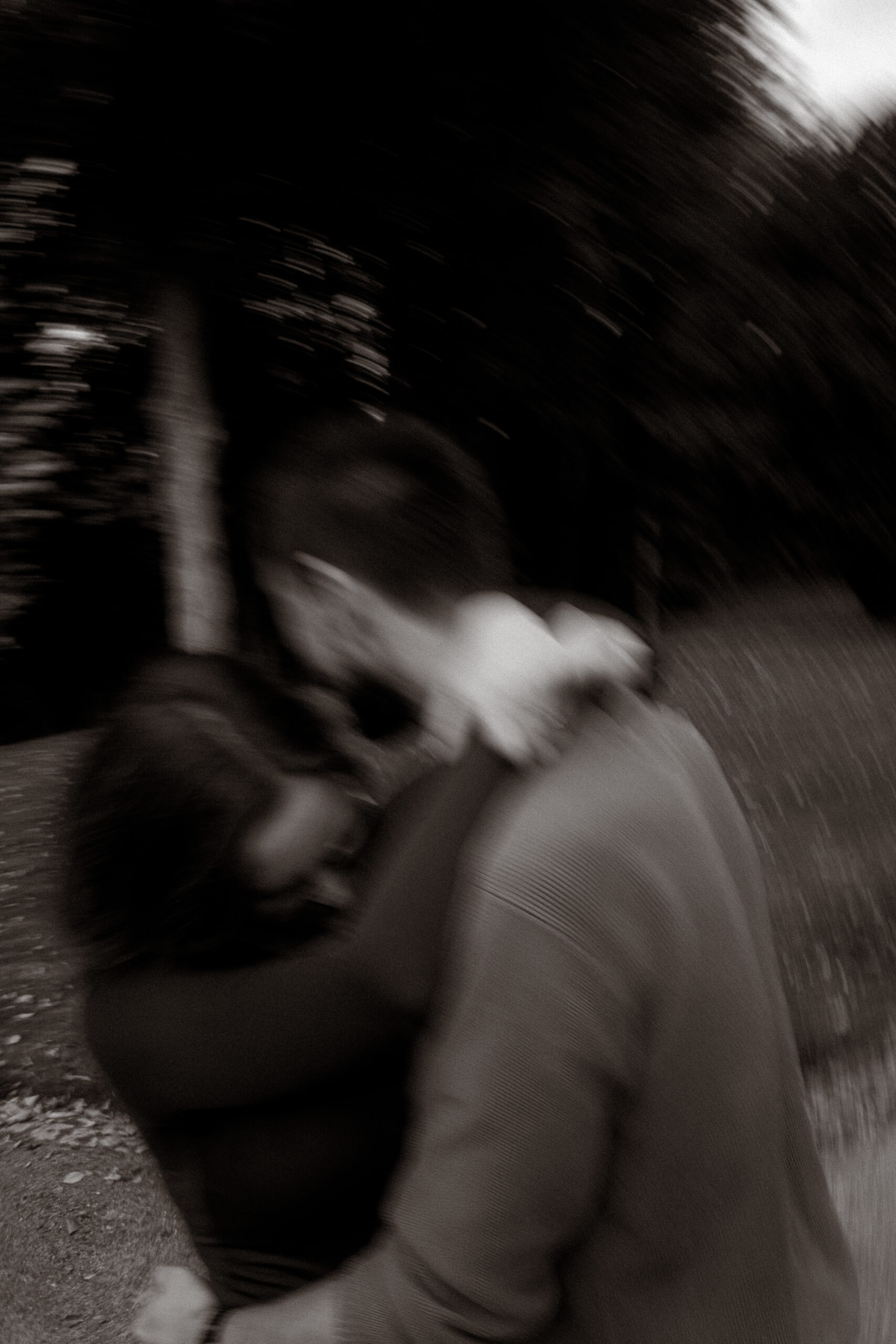 Pärchenshooting Basthorst: Unscharfes Foto eines sich umarmenden Paares im Park.