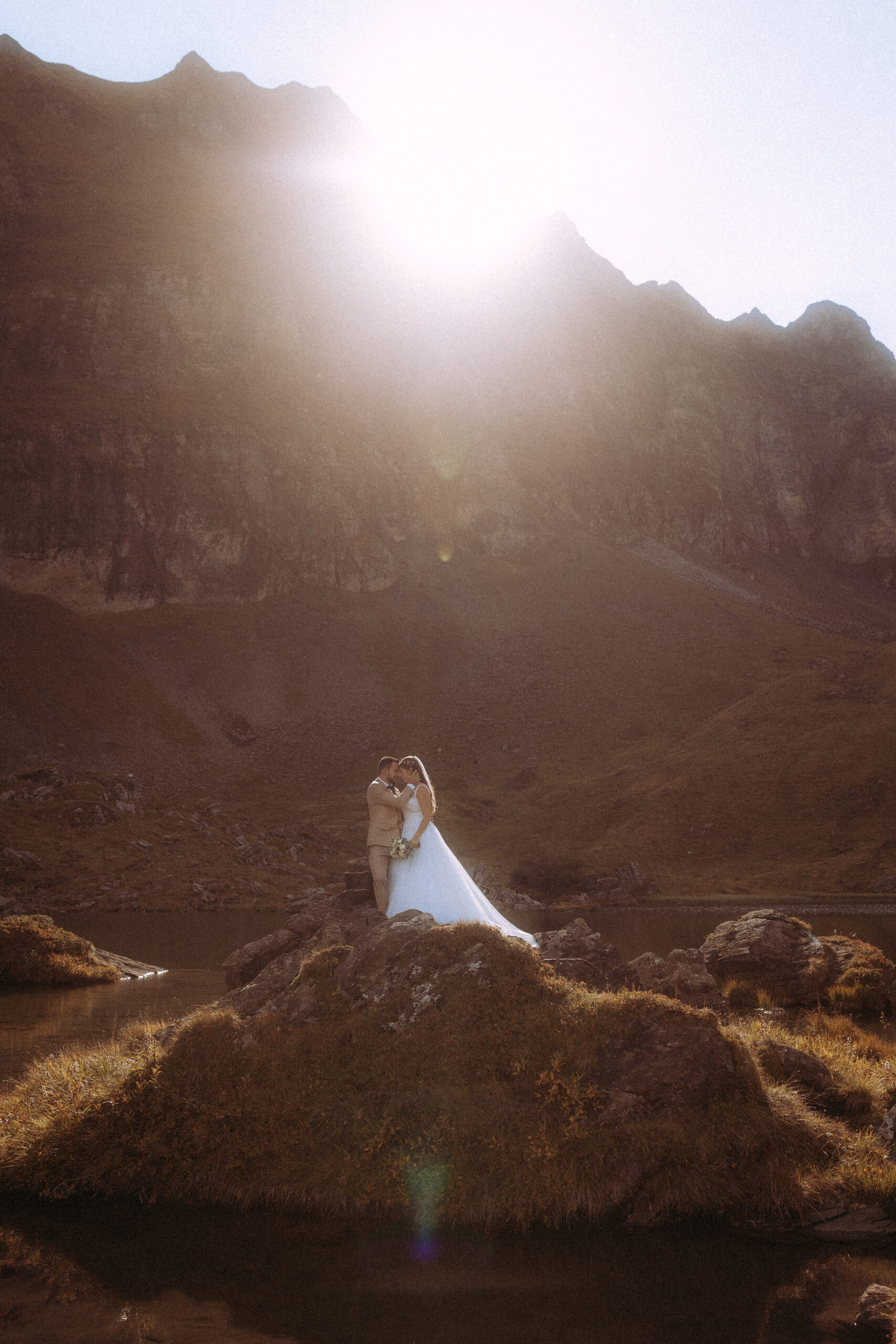 Hochzeitsfoto: Brautpaar küsst sich in den Bergen. Destination Wedding in atemberaubender Natur.
