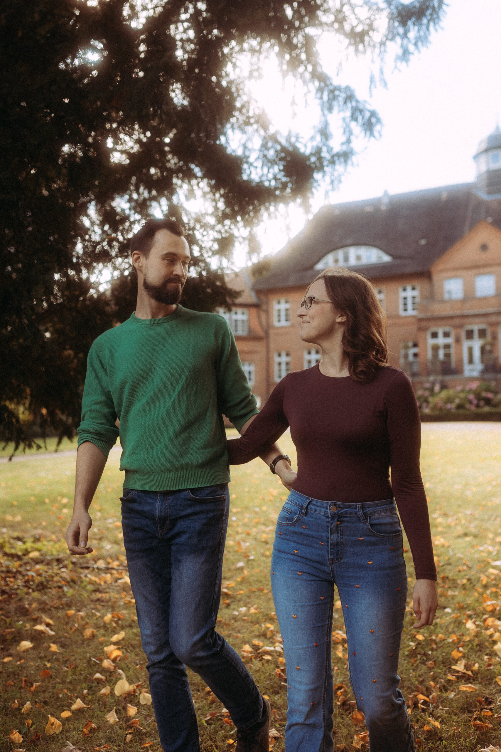 Paar spaziert vor einem Backsteingebäude im Portfolio