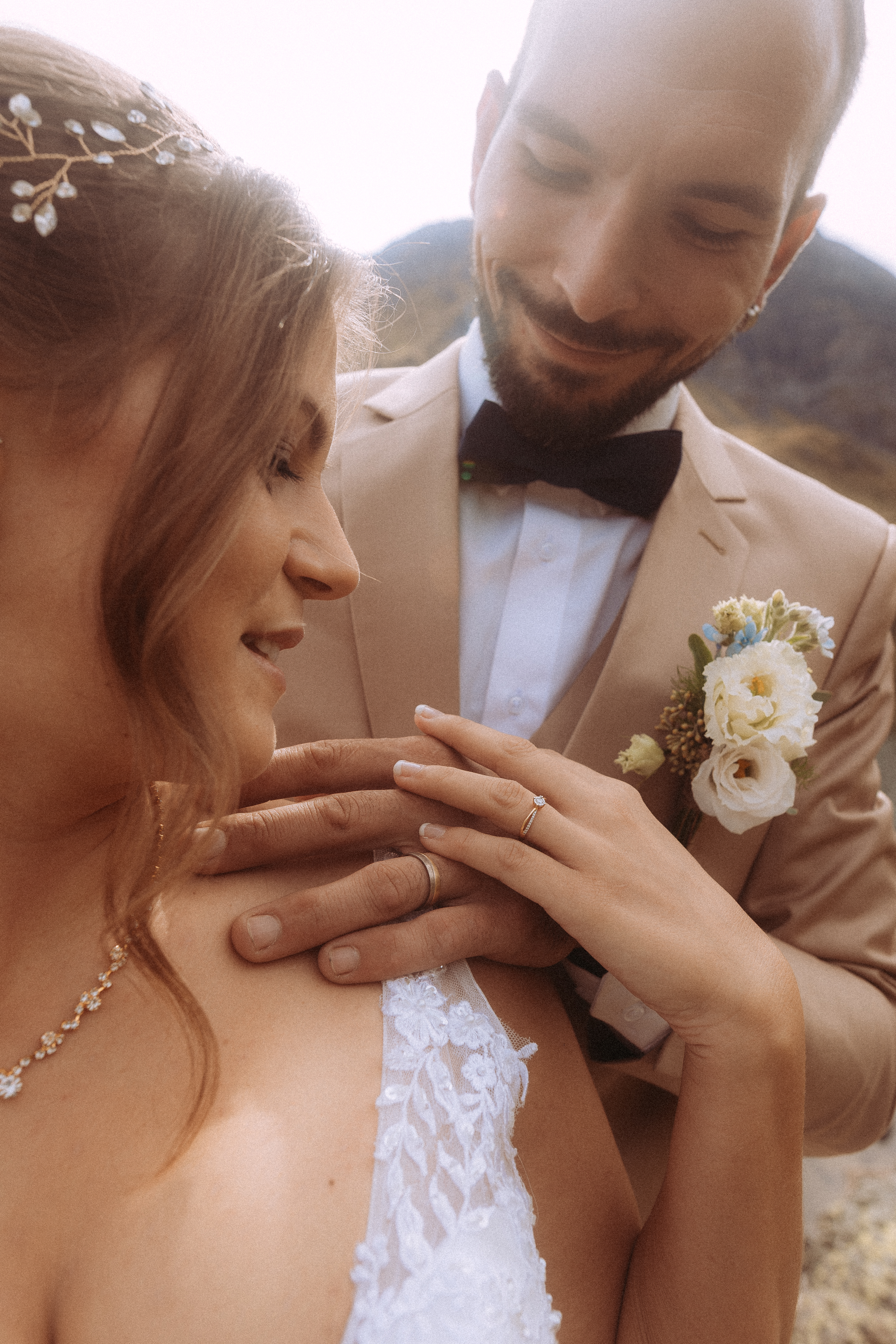 Brautpaar bei Hochzeitsshooting Melchsee-Frutt. Glücklicher Bräutigam legt Hände auf Braut.
