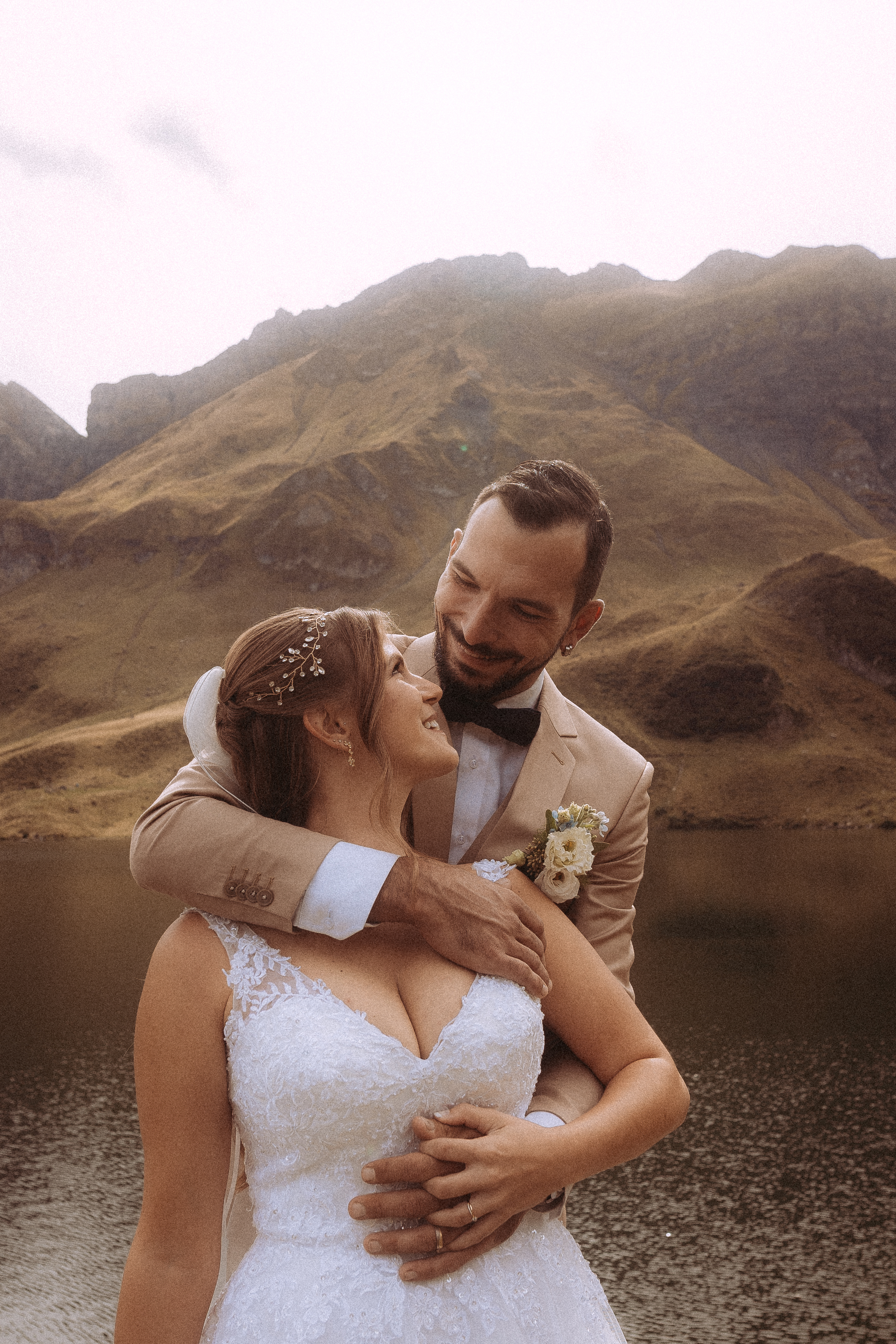 Hochzeitsshooting Melchsee Frutt: Brautpaar umarmt sich vor Bergsee. Liebe in der Schweiz.