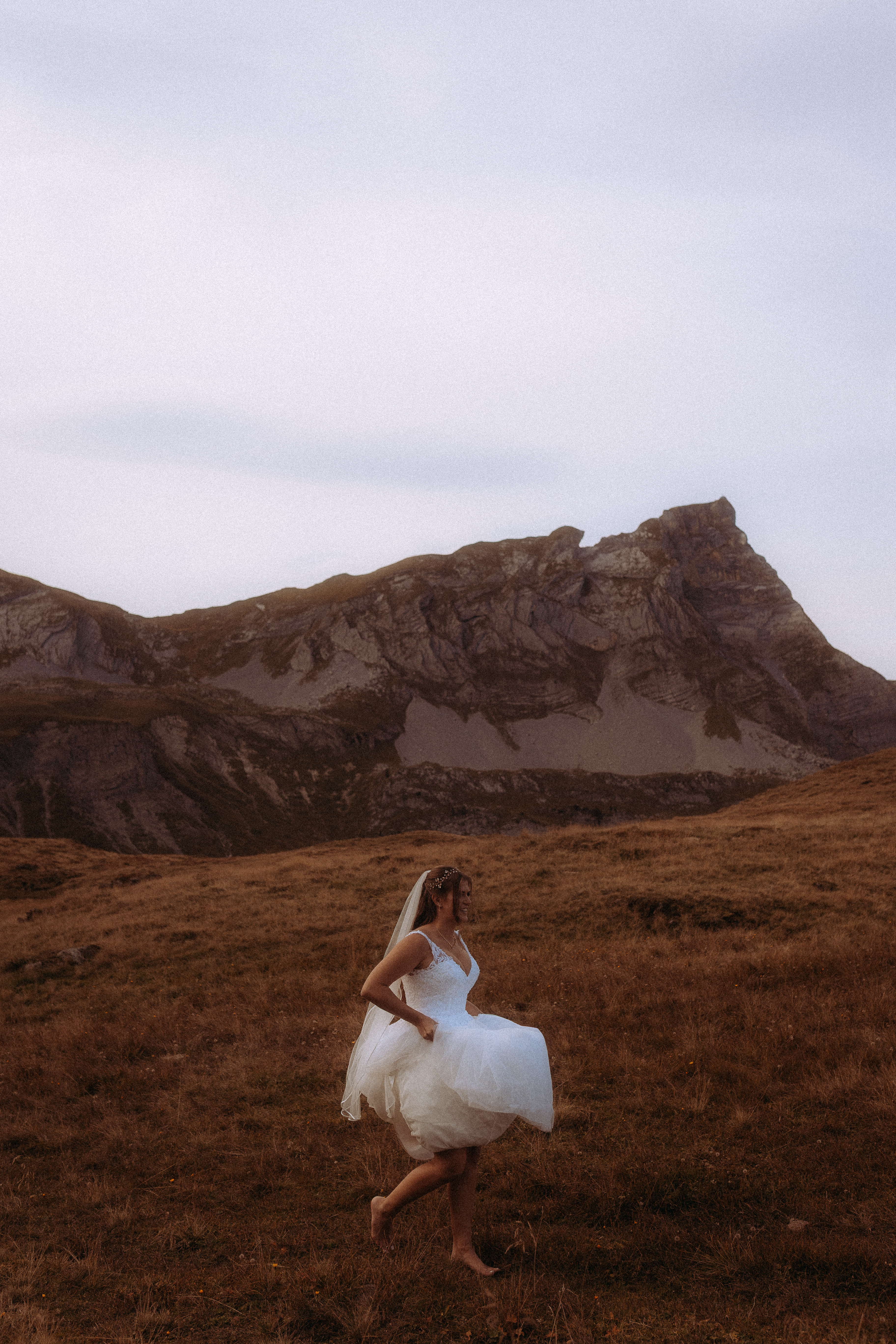 Braut im Hochzeitskleid barfuß in den Bergen beim Wedding Shooting Melchsee Frutt Schweiz