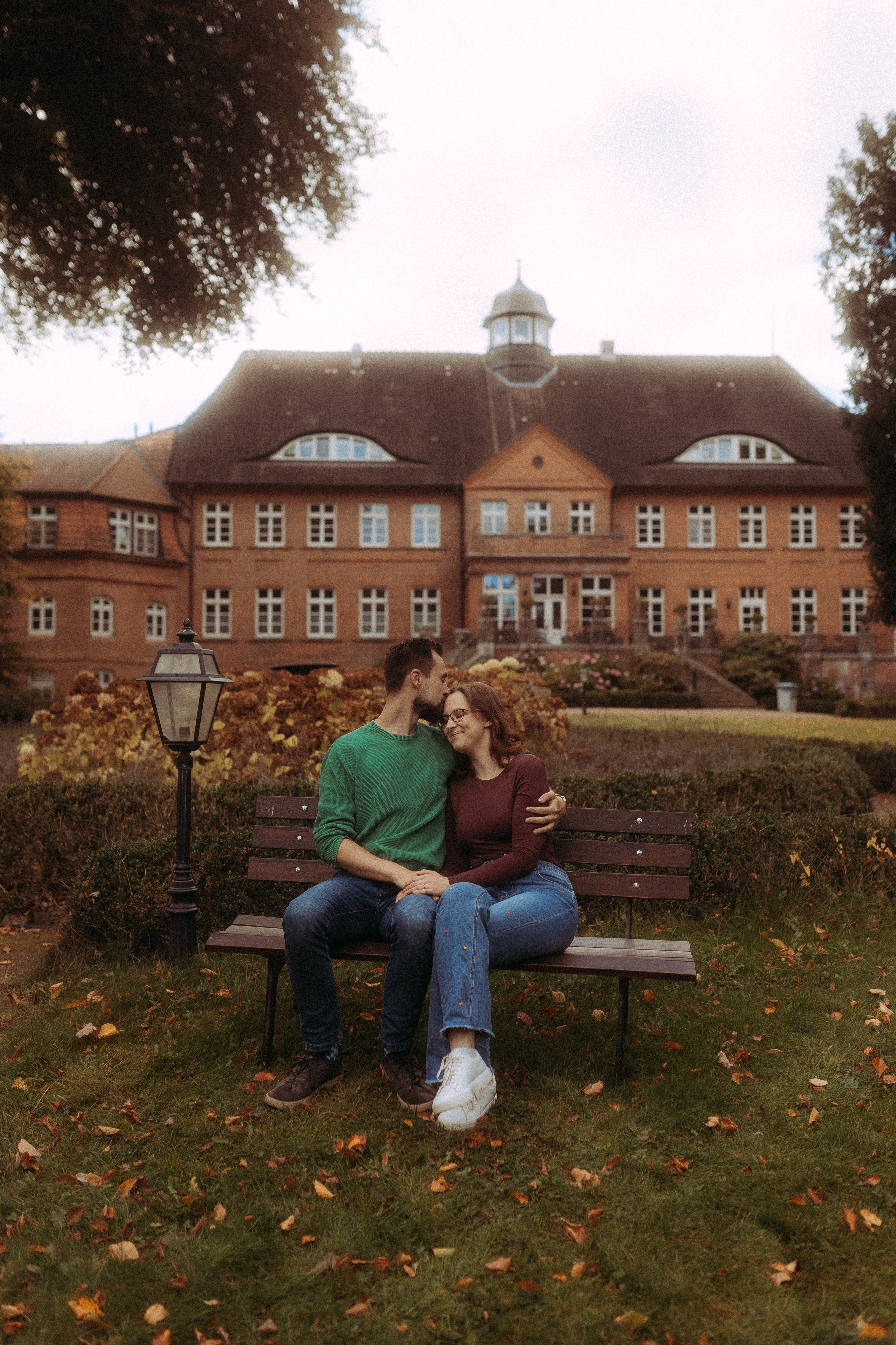 Verliebtes Paar sitzt auf Bank vor Schloss, möglicherweise Hochzeitsshooting Melchsee Frutt