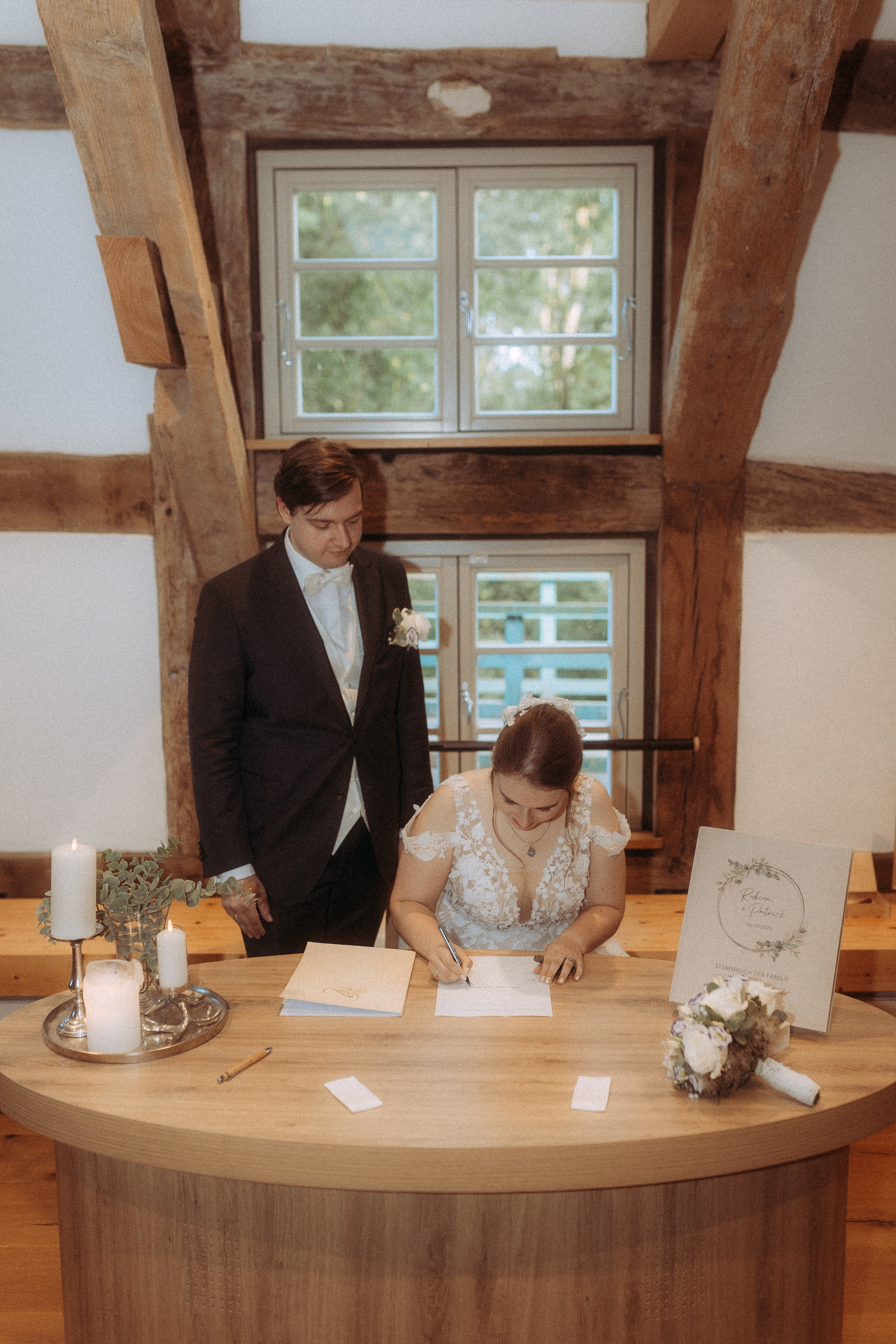 Brautpaar unterschreibt Dokument bei standesamtlicher Hochzeit in Friedland (MV)