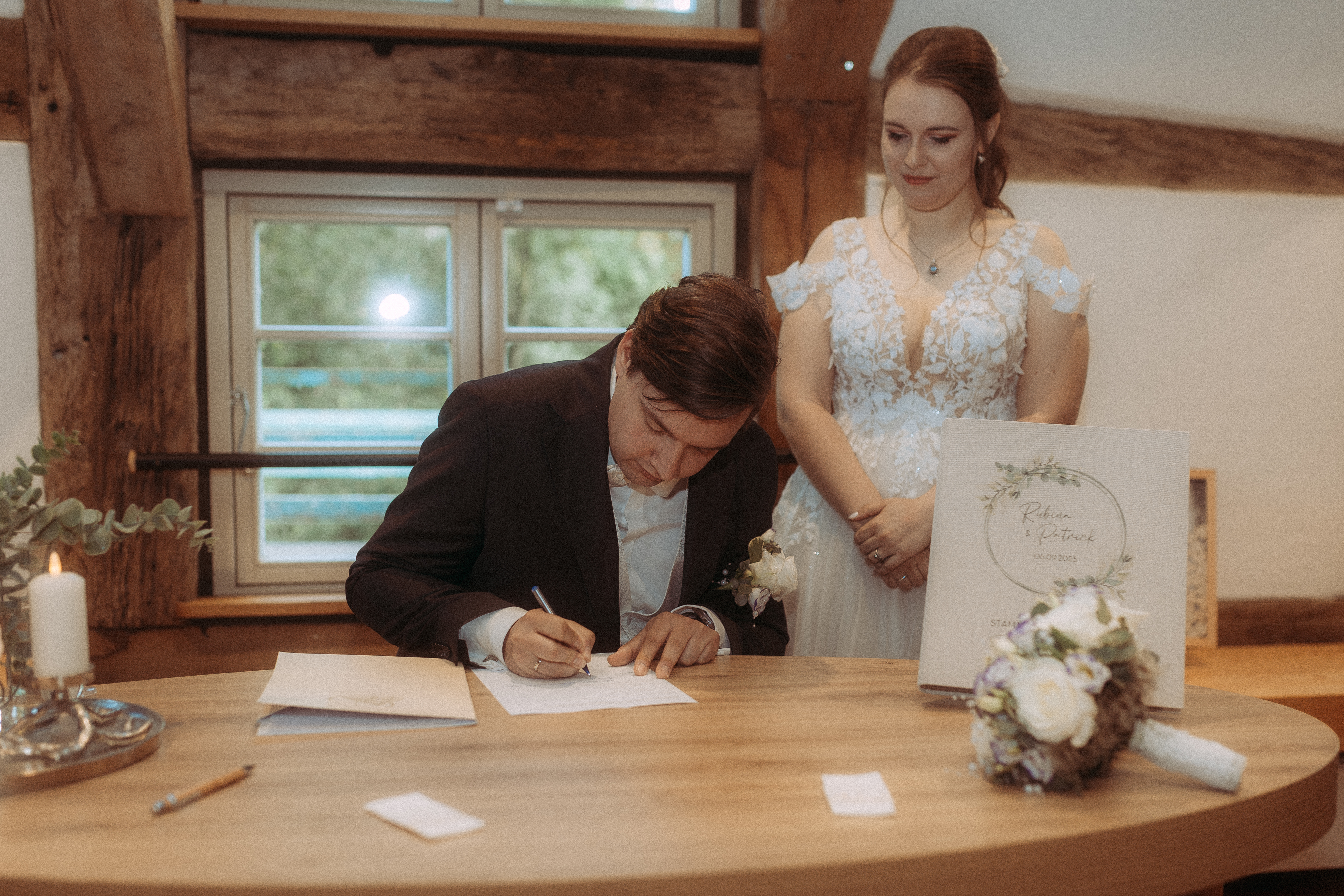 Brautpaar unterschreibt Dokument bei der standesamtlichen Hochzeit in Friedland (MV)