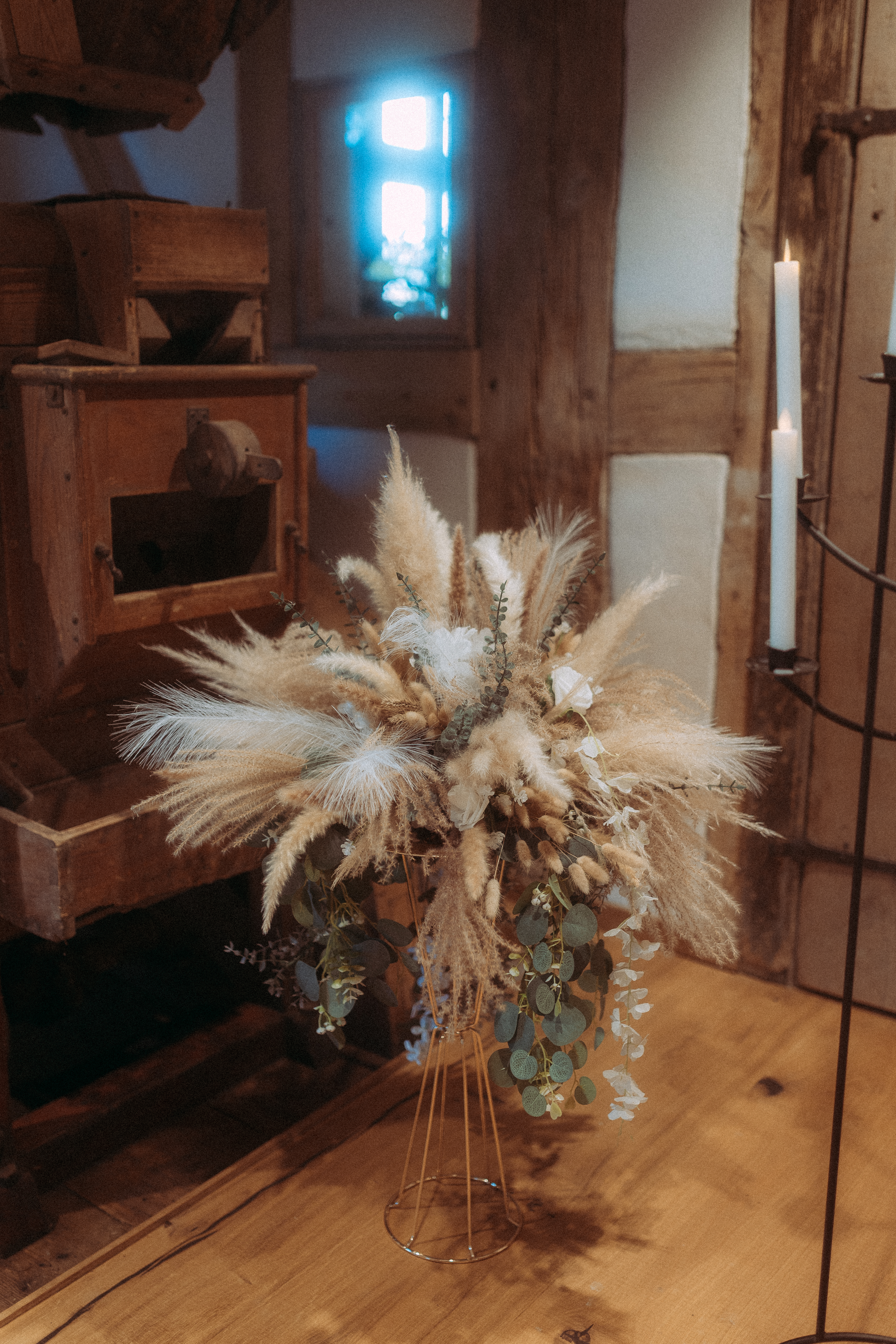 Dekorative Trockenblumenarrangements in rustikalem Ambiente mit Kerzen und Holzdetails