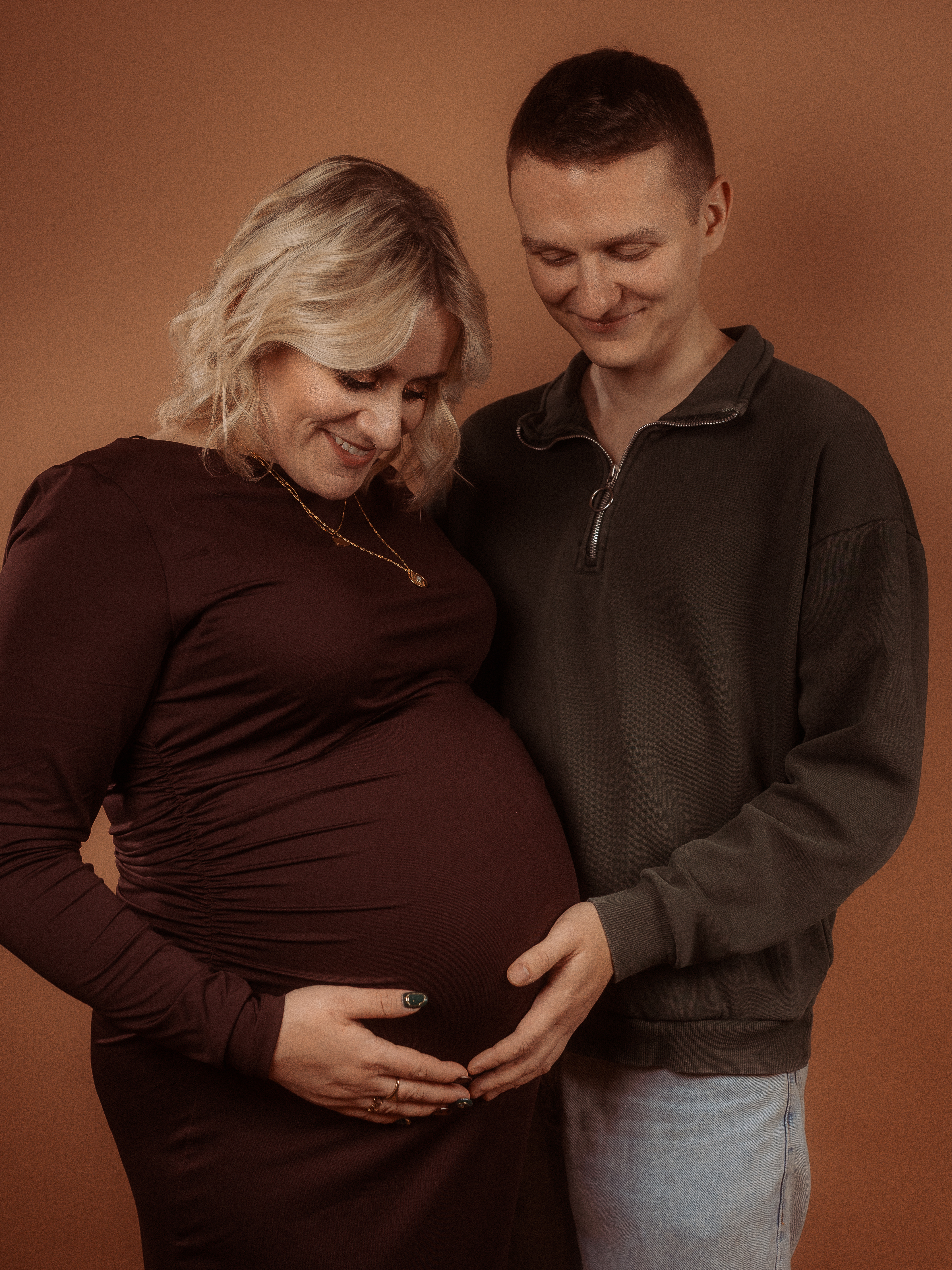Schwangere Frau und Mann beim Babybauchshooting in Parchim. Liebevolle Pose mit Händen auf dem Bauch.