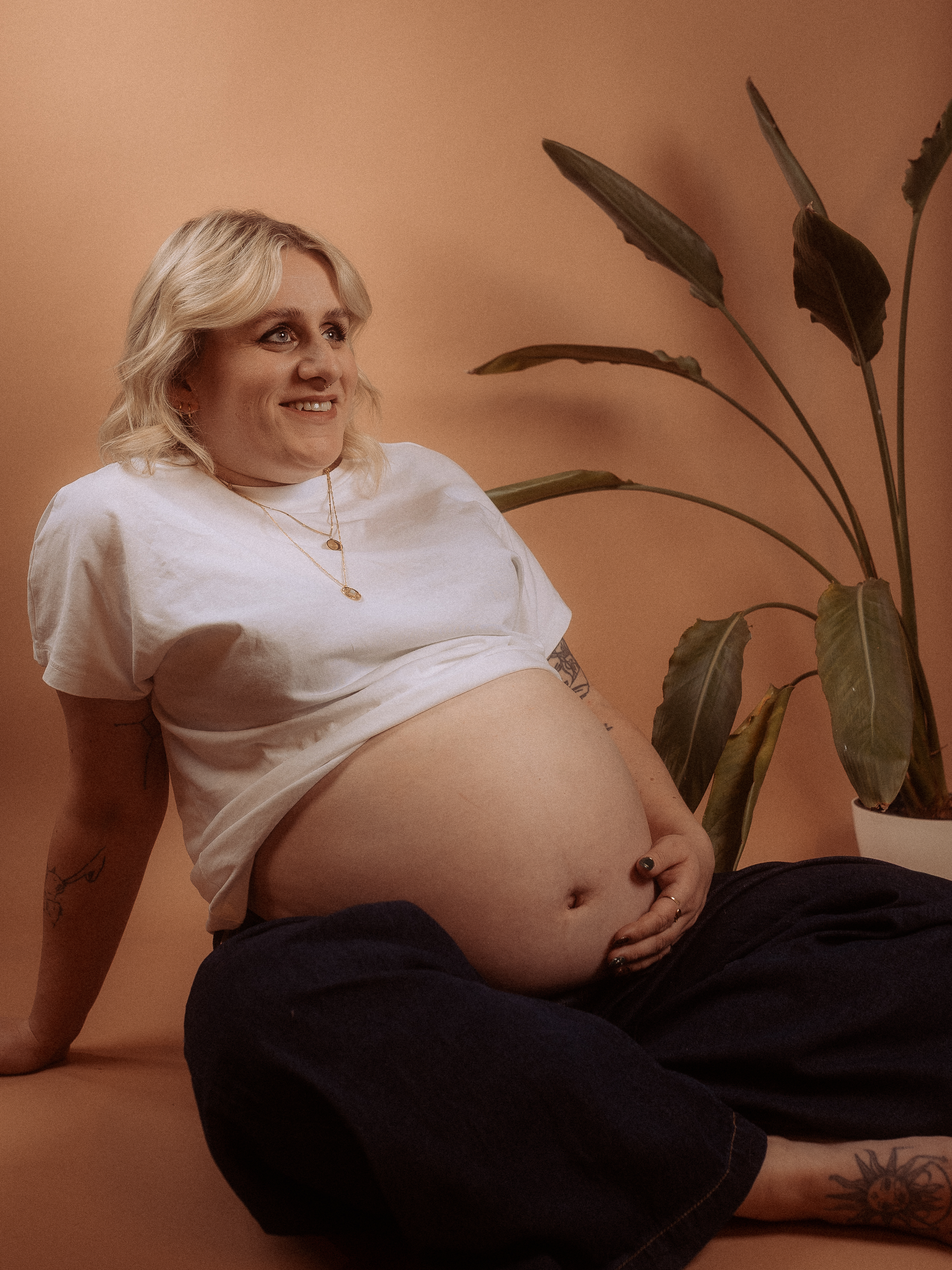 Schwangere Frau sitzt mit Babybauch beim Babybauchshooting in Parchim