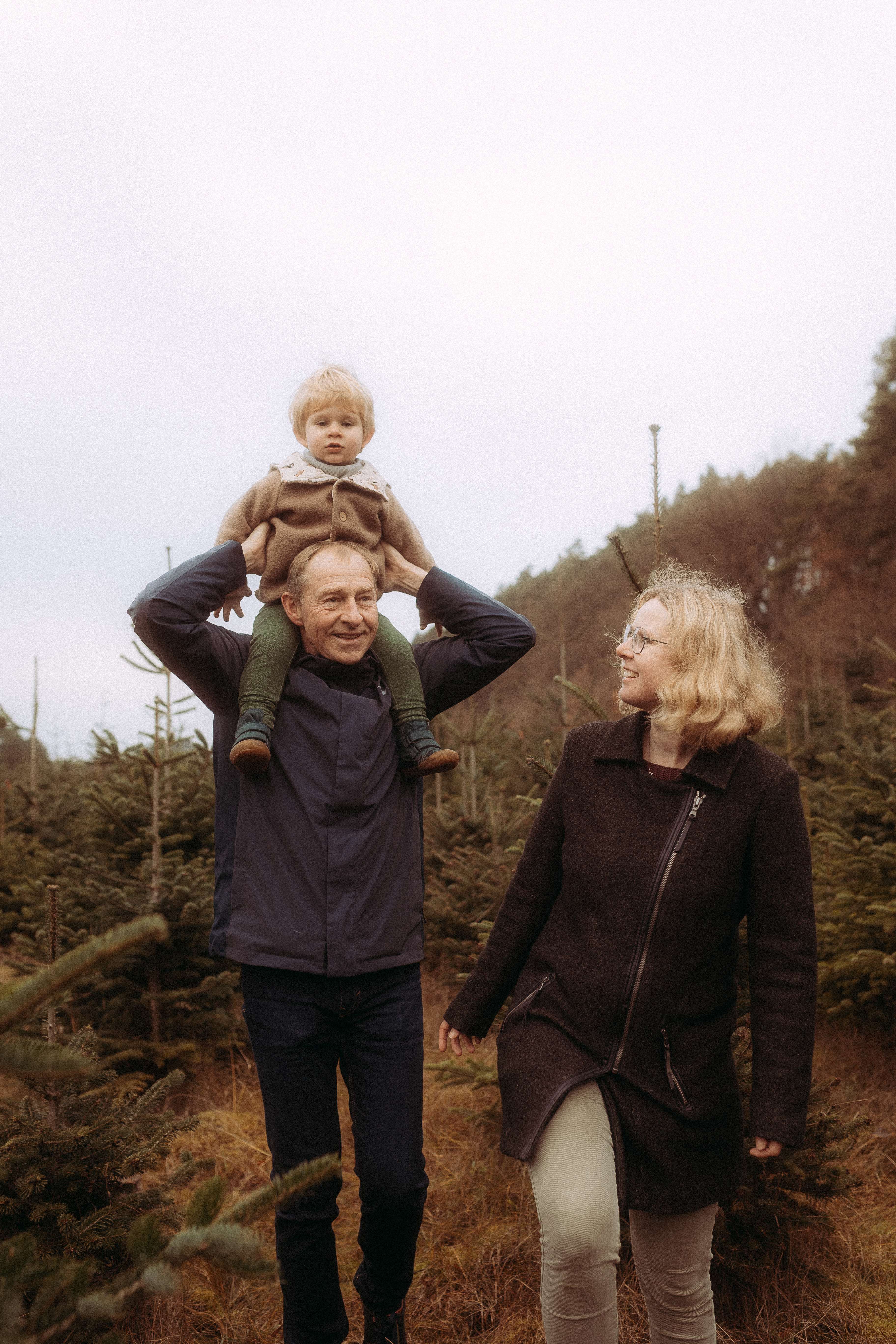 Familie beim Pärchenshooting in Basthorst: Opa trägt Enkel, Oma geht daneben.