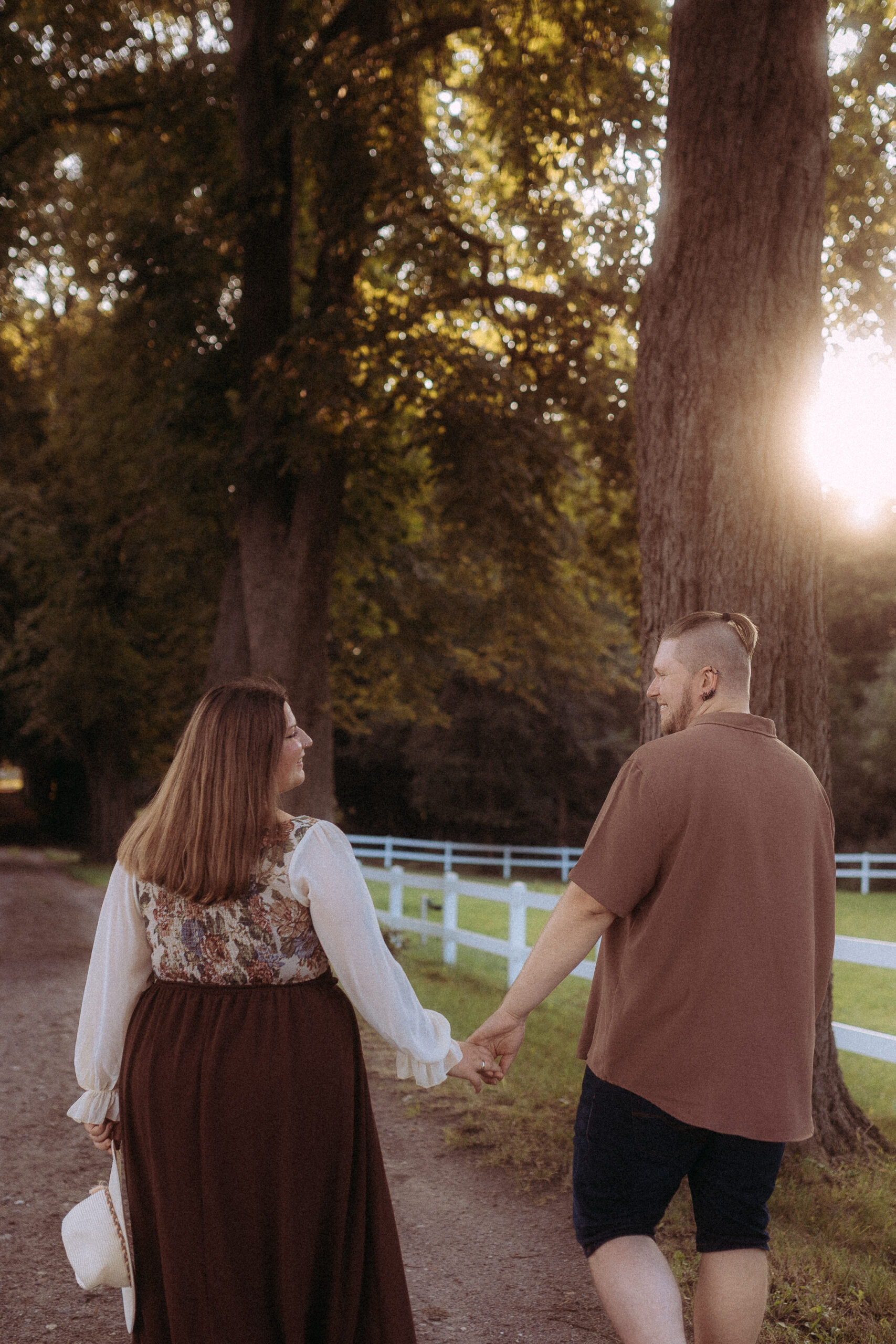Pärchen hält Händchen auf einem Weg in Röbel, Bäume im Hintergrund