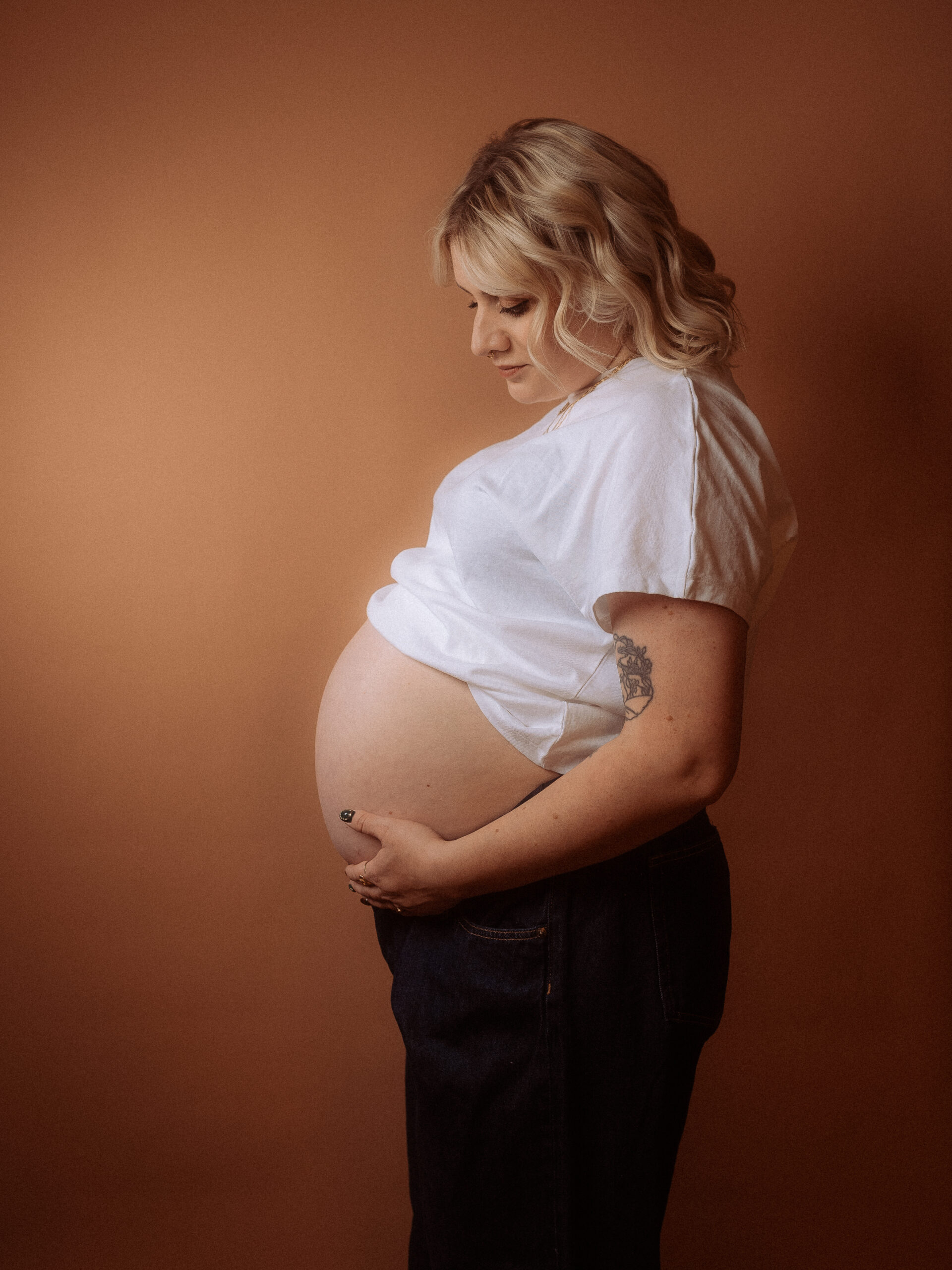 Schwangere Frau beim Babybauchshooting in Parchim hält ihren Bauch.