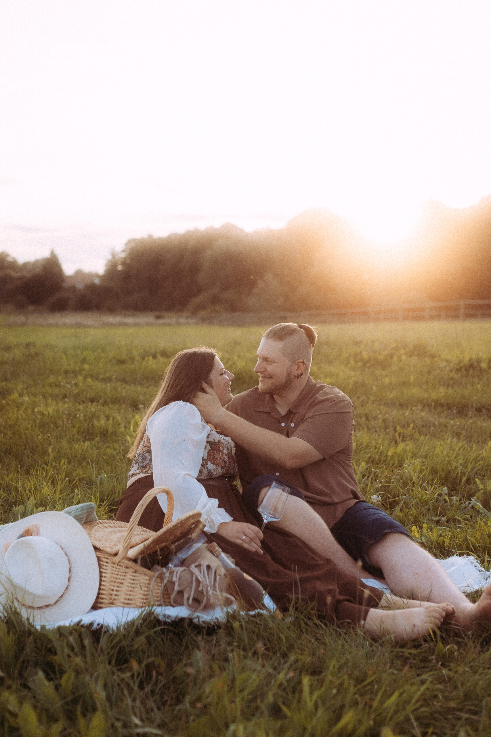 Verliebtes Paar macht Picknick im Grünen bei Sonnenuntergang. Romantische Szene.