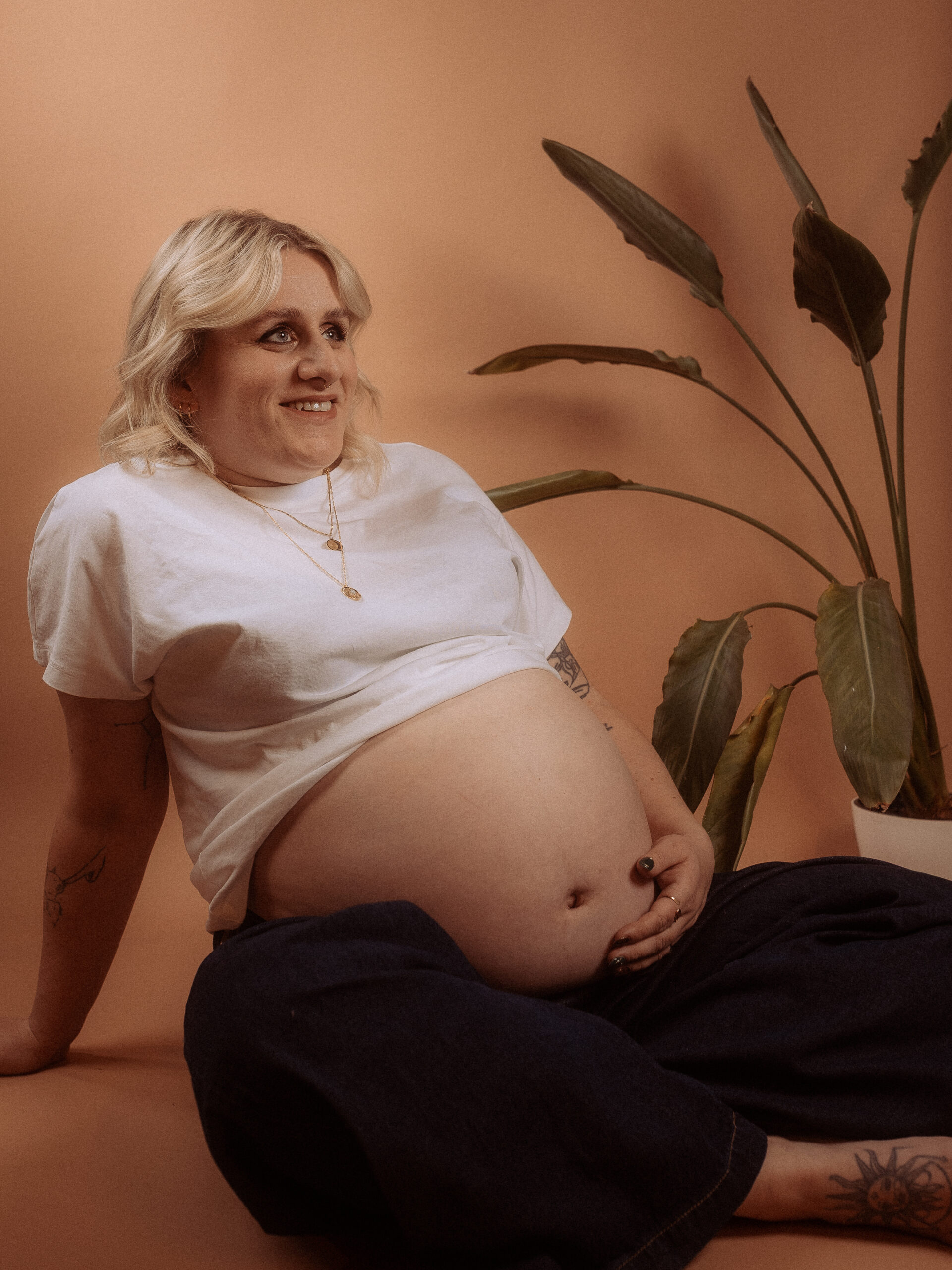 Schwangere Frau sitzt mit Babybauch beim Babybauchshooting in Parchim