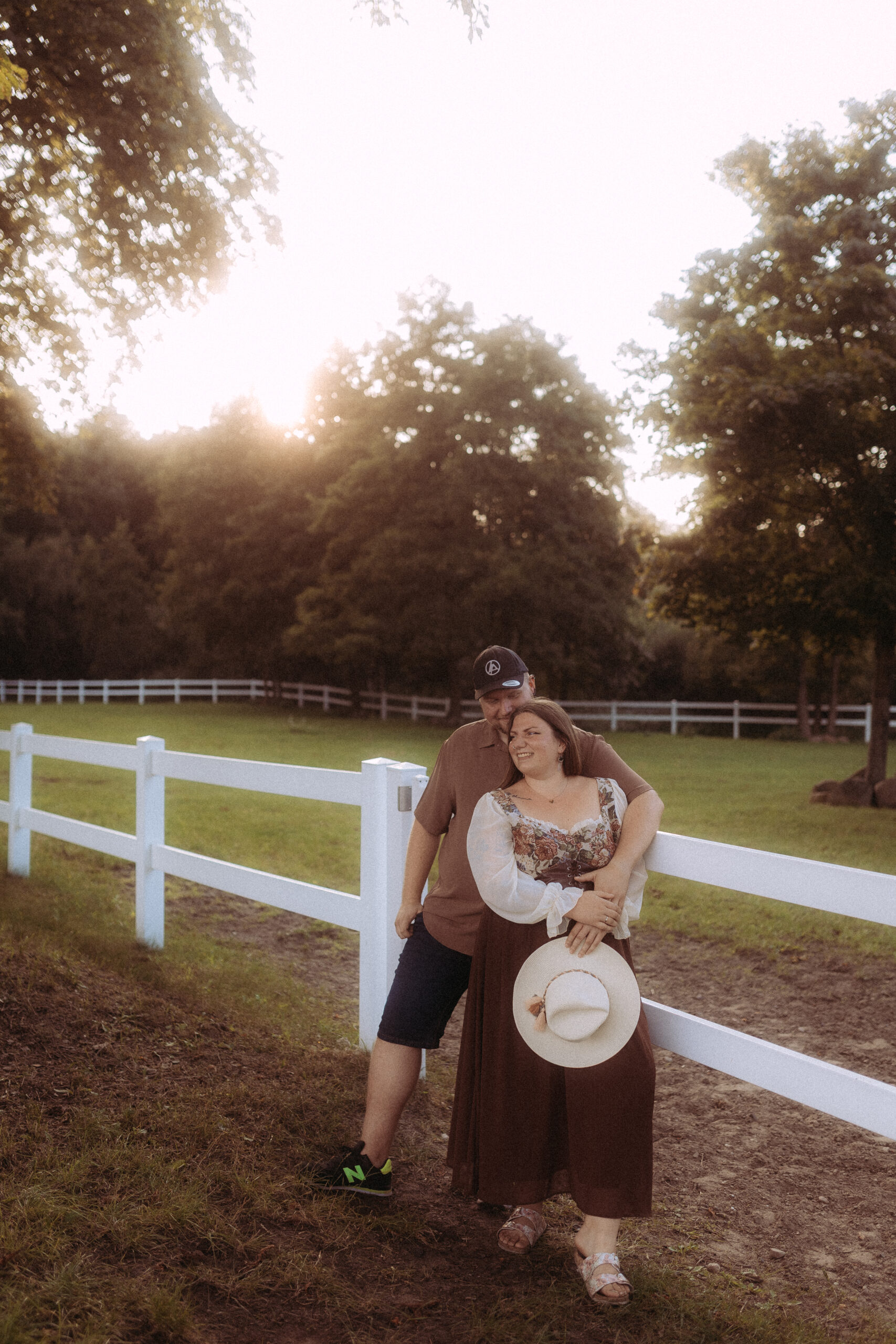 Paar umarmt sich an einem Zaun. Fotograf in Schwerin könnte dieses Paar fotografiert haben.