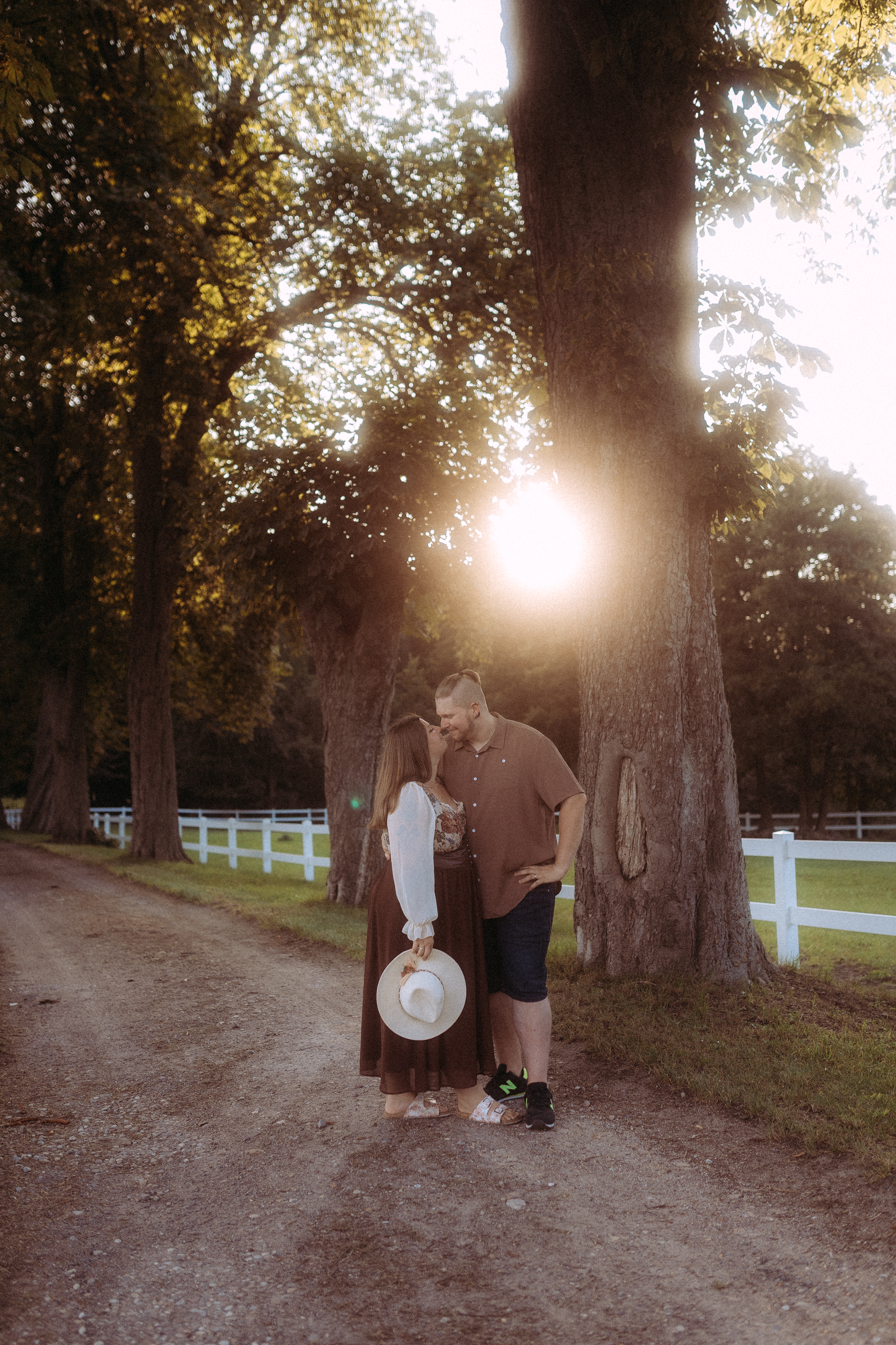 Pärchenfotos in Röbel: Paar küsst sich auf einem Feldweg unter Bäumen