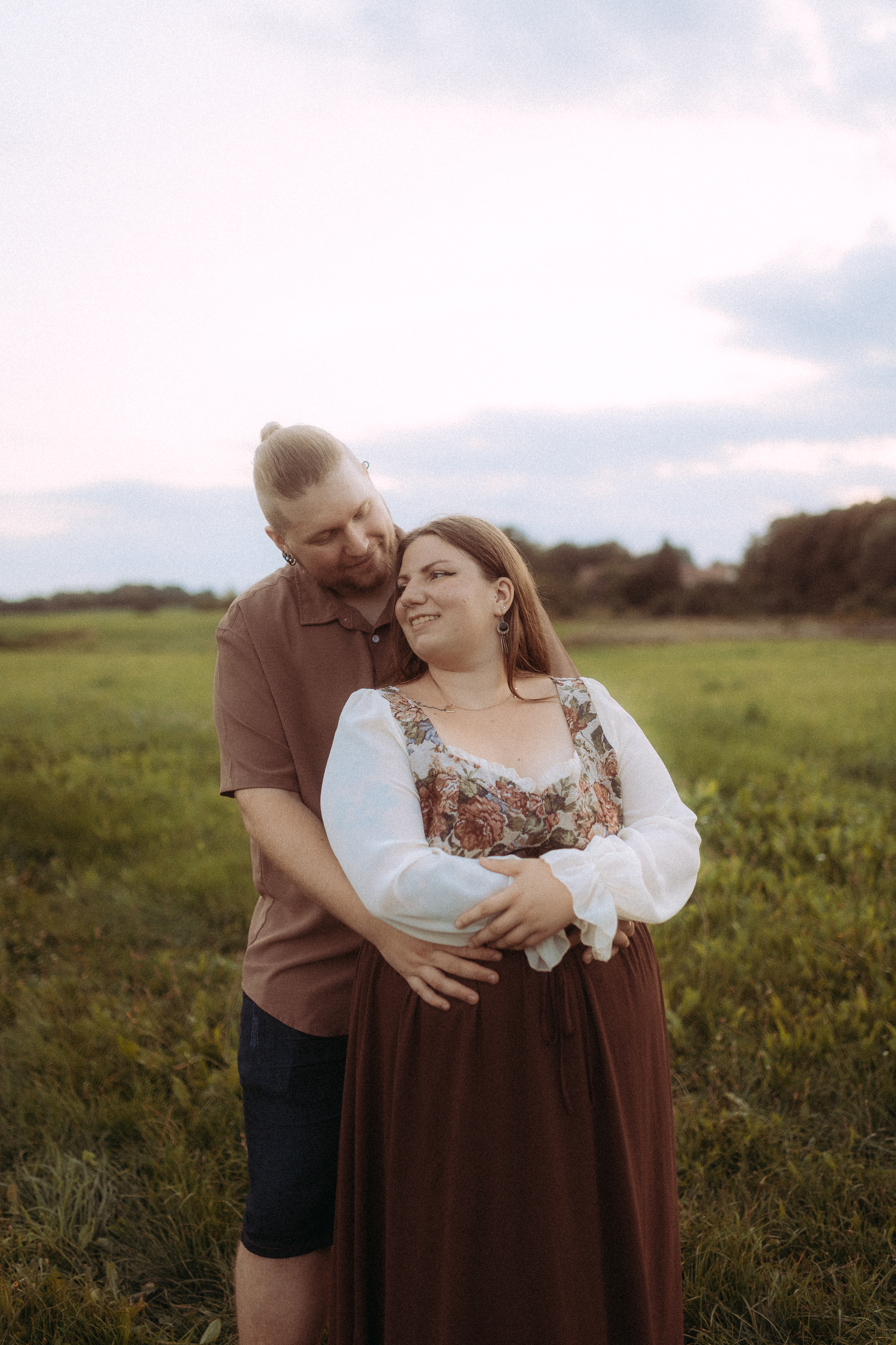 Pärchenfotos in Röbel: Glückliches Paar umarmt sich in grüner Landschaft