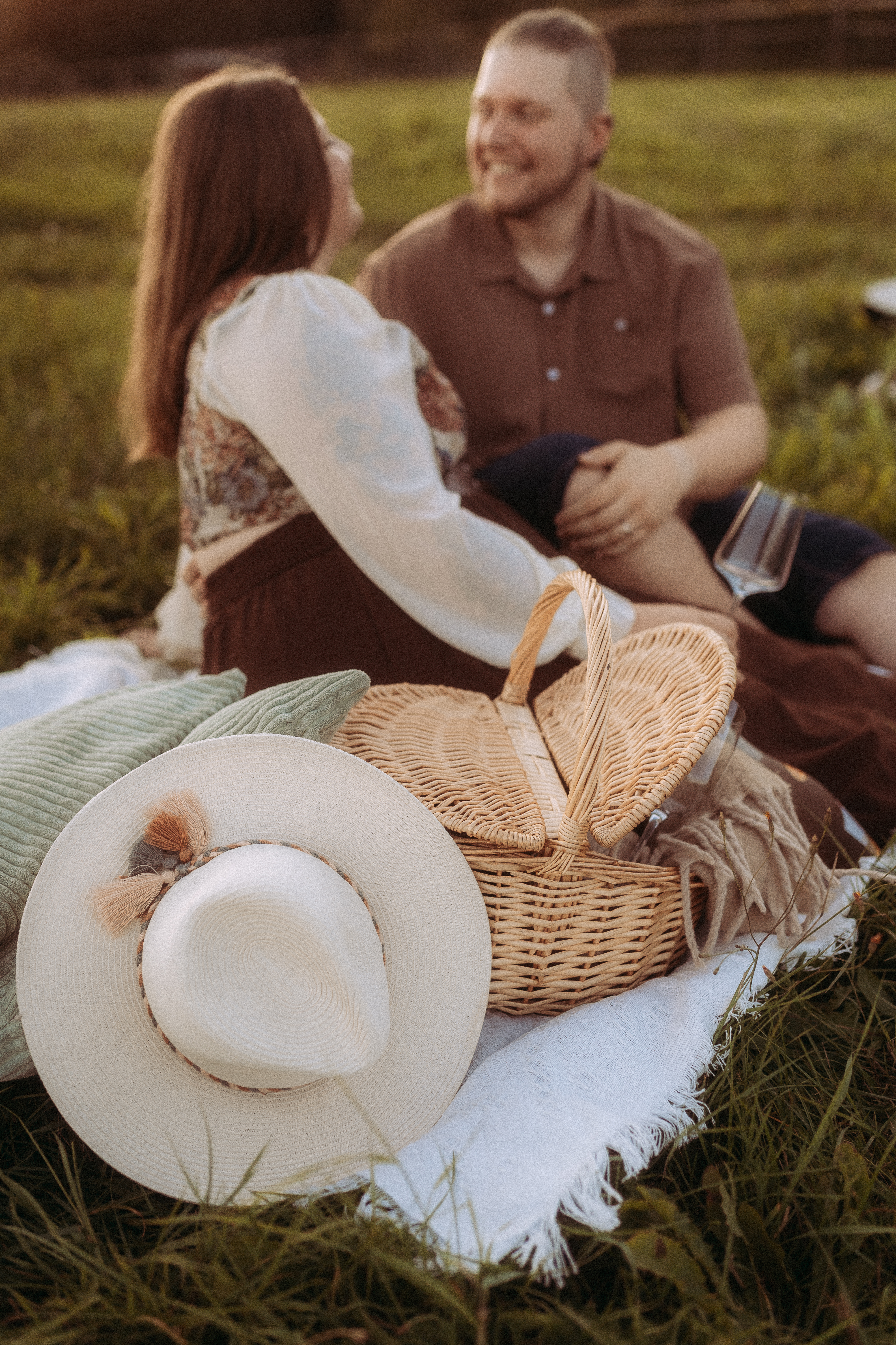 Pärchenshooting in Basthorst: Paar beim Picknick im Grünen mit Korb und Hut