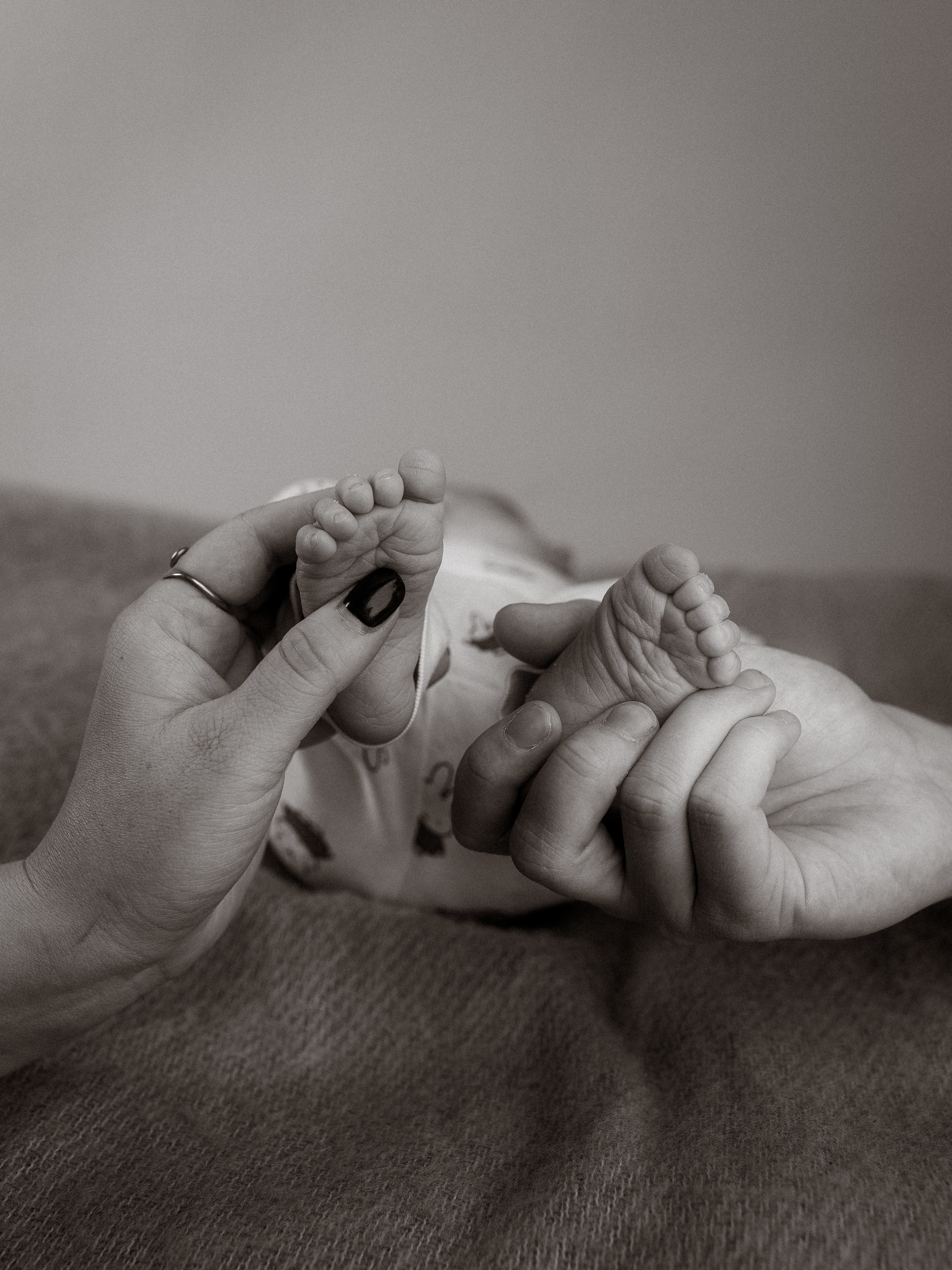 Zarte Babyfüße in Elternhänden, liebevolle Geste der Geborgenheit und Zuneigung.
