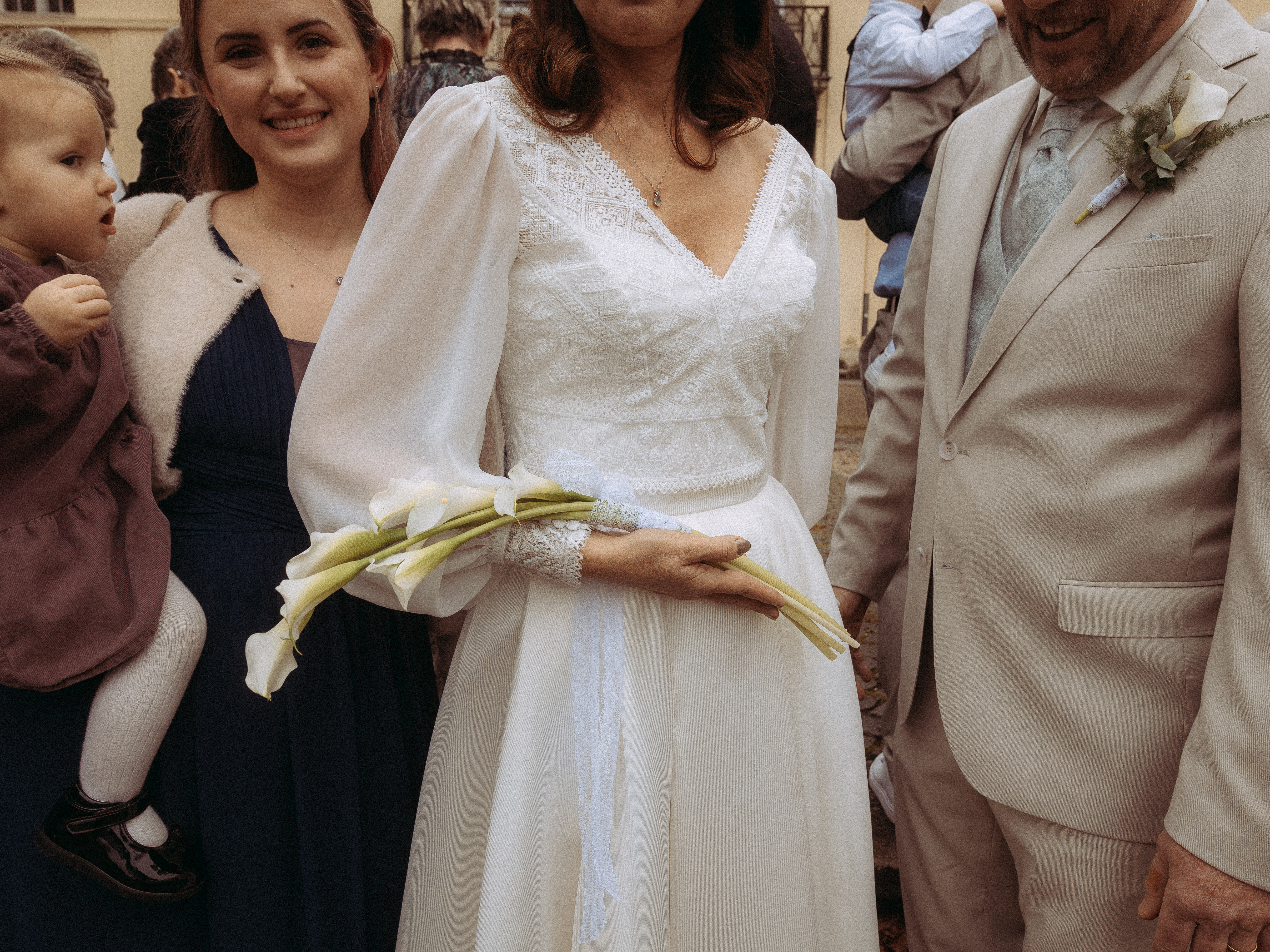 Braut mit Calla Lilien Bouquet, umgeben von Familie. Hochzeitsfoto.