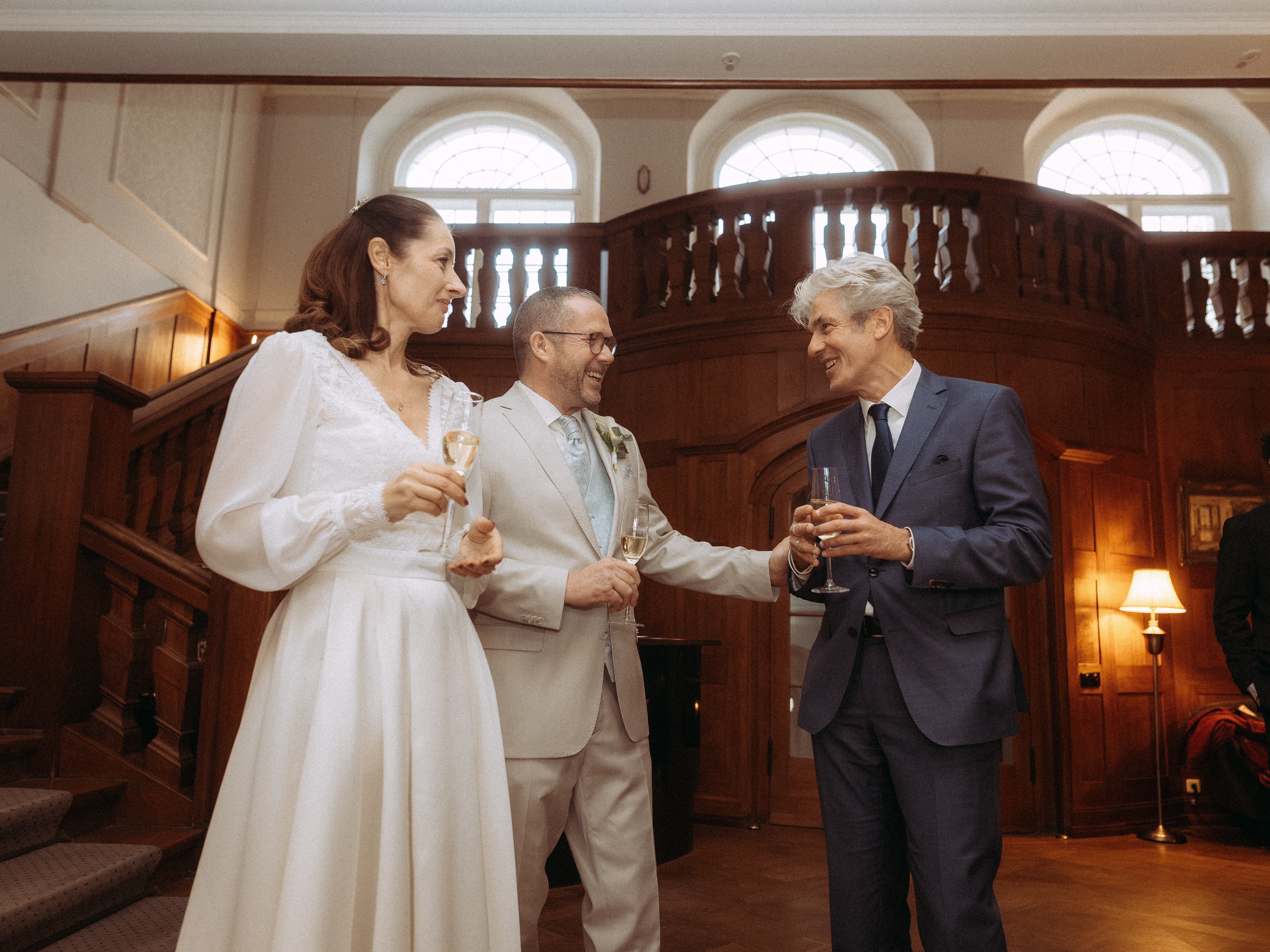 Bride, groom, and guest toasting at a sustainable wedding reception