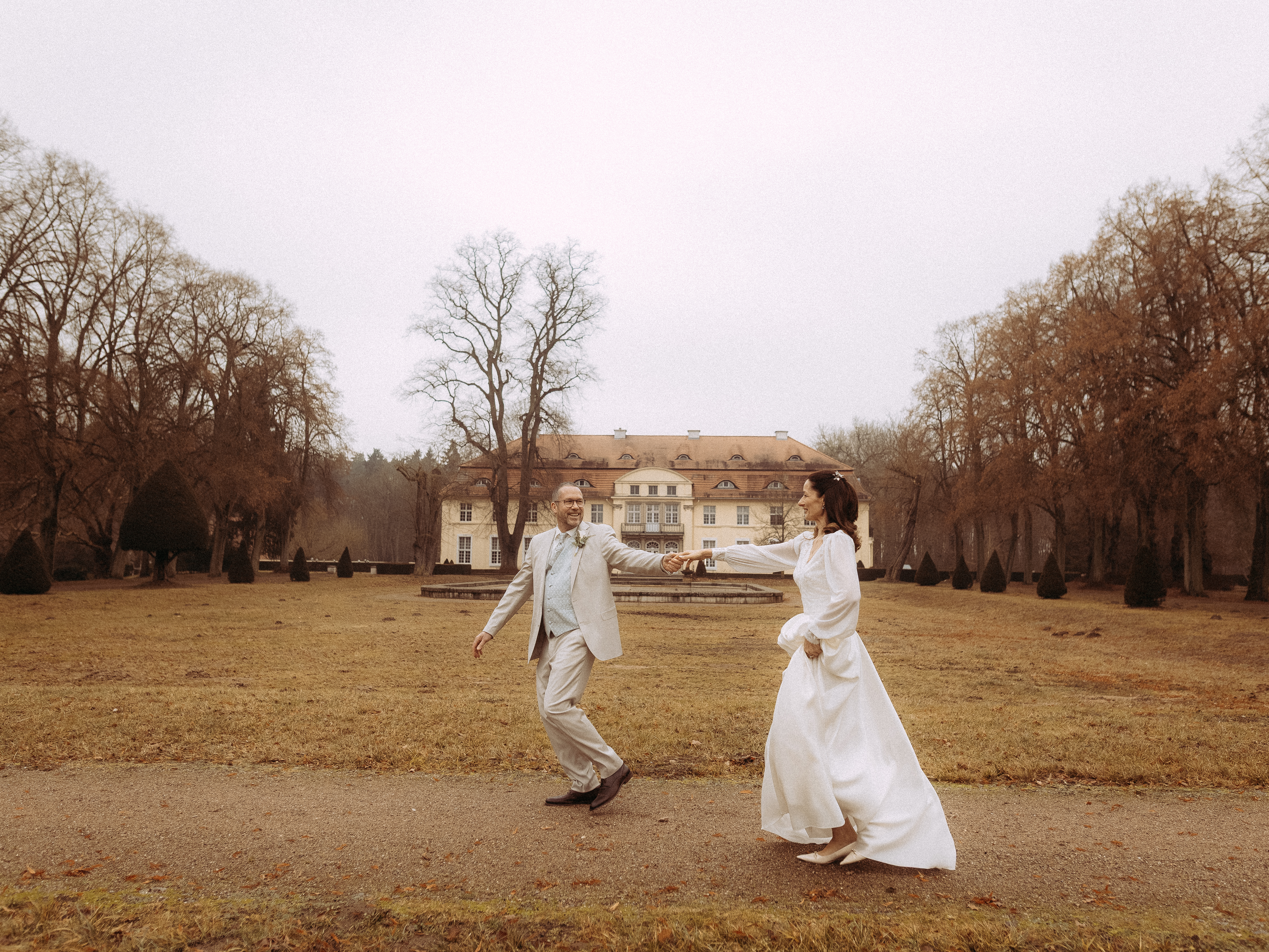 Ein Paar joggt in der Nähe einer großen Villa unter bewölktem Himmel.