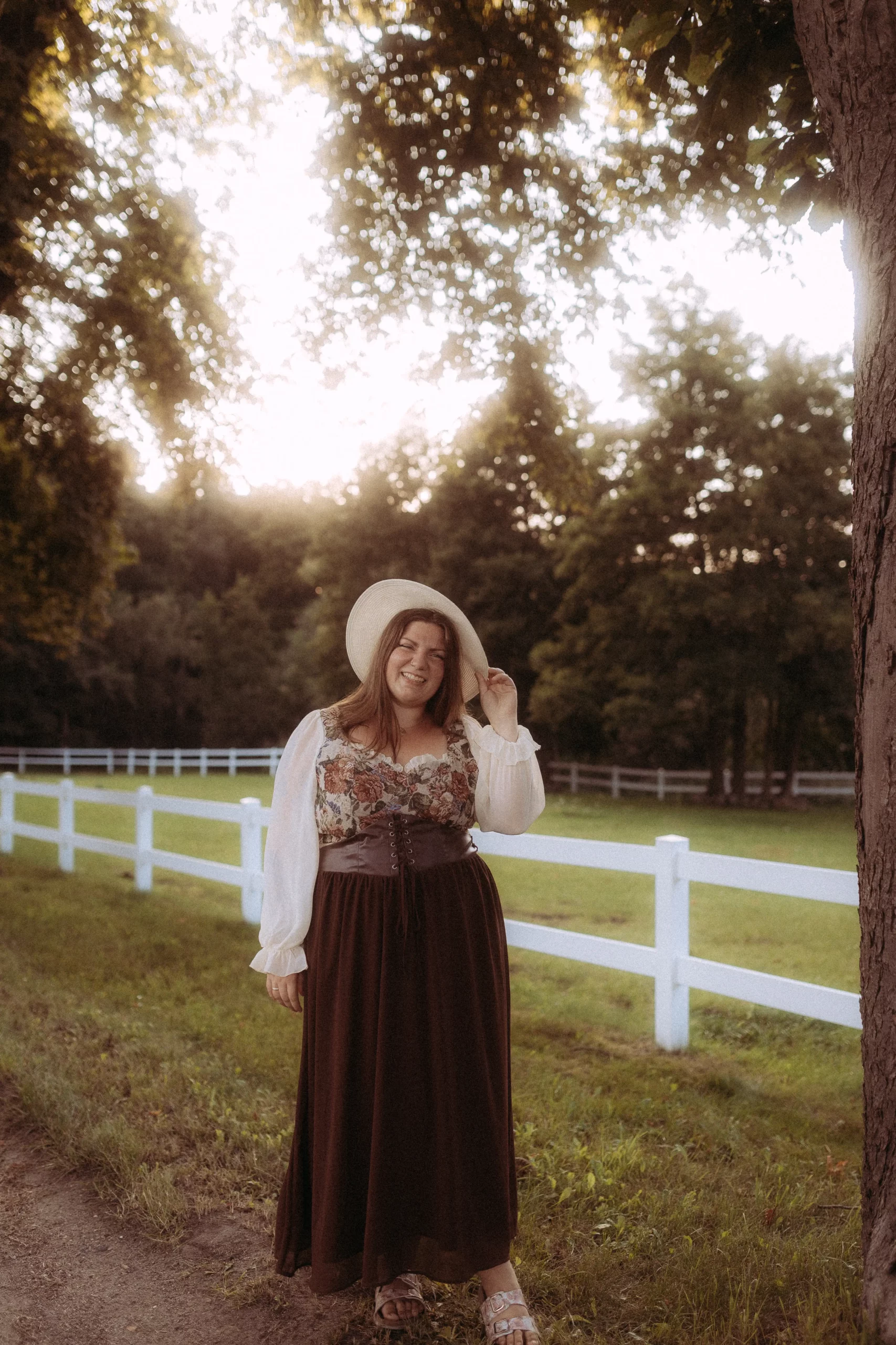 Woman in long dress and hat smiling