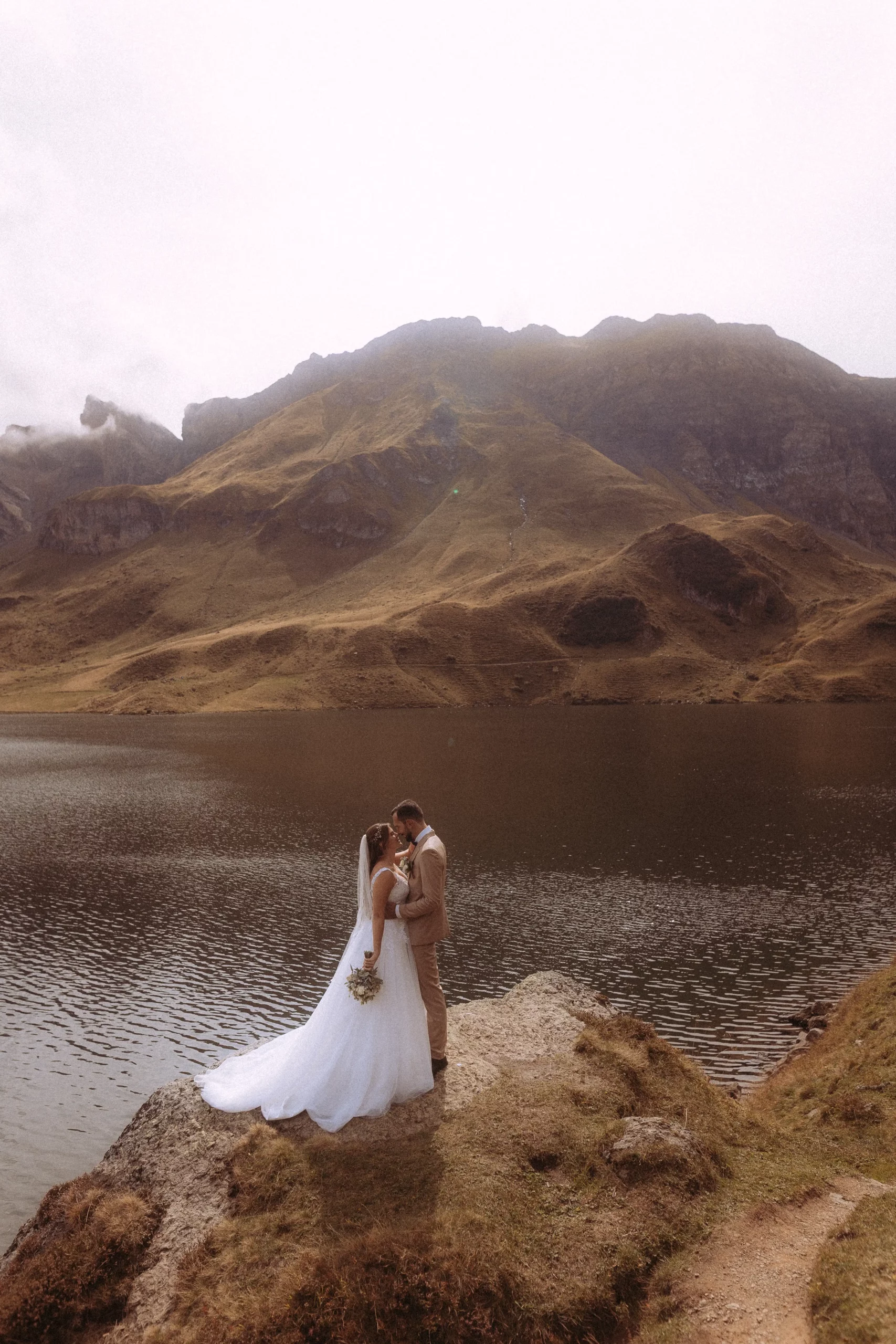 Hochzeitsfotograf in den Alpen: Brautpaar am Bergsee