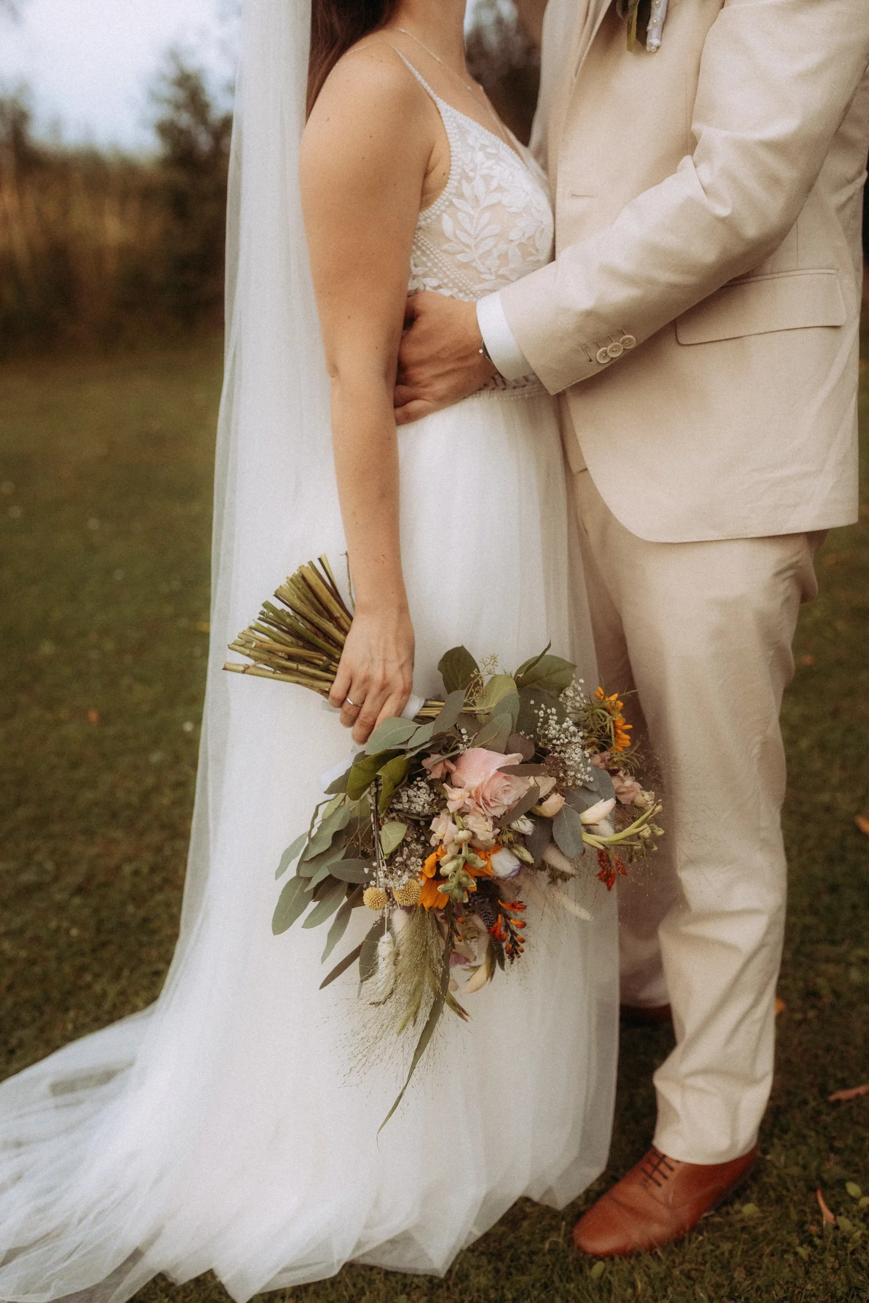 Brautpaar mit Blumenstrauß bei Hochzeit