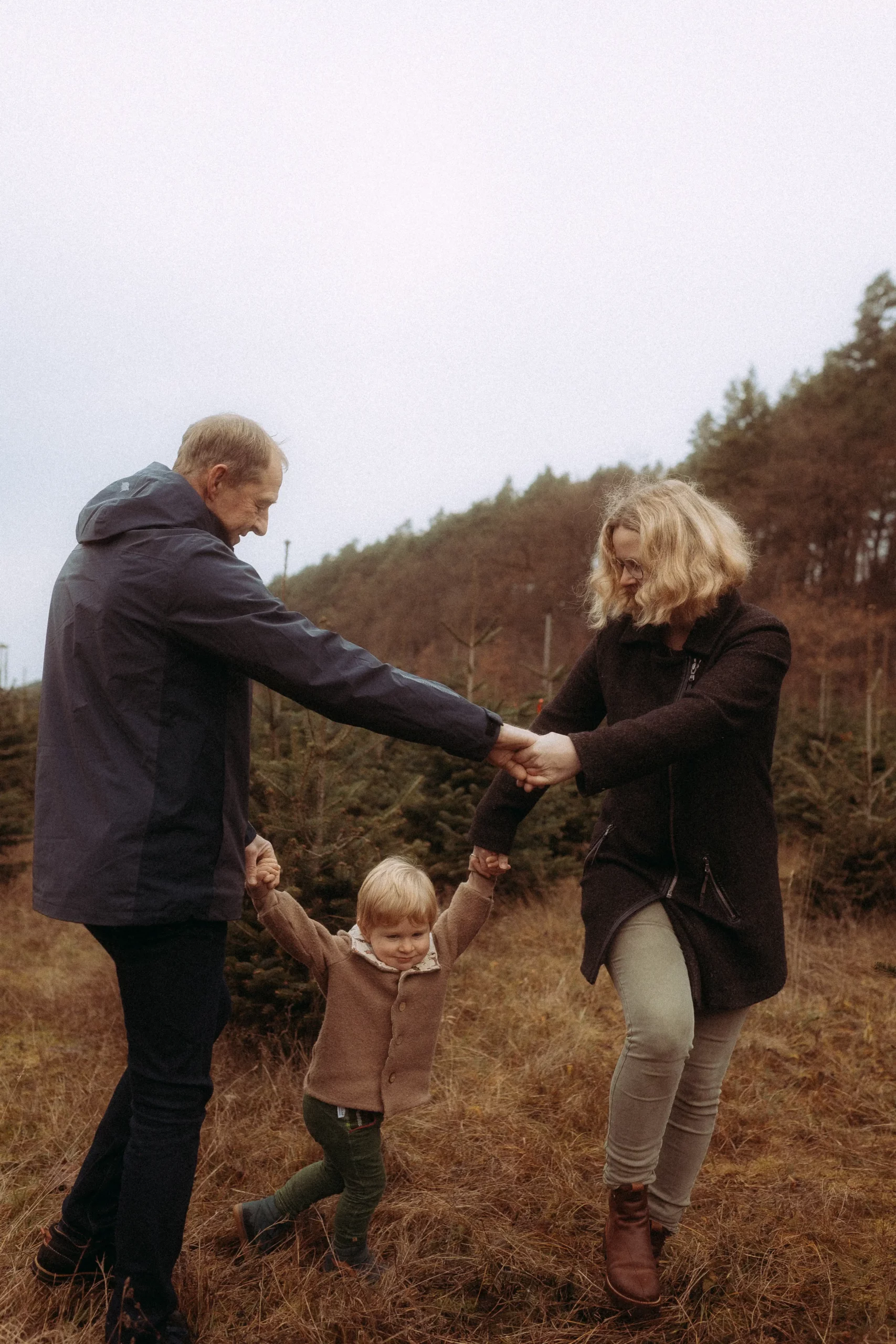 Familie tanzt auf einer Wiese.