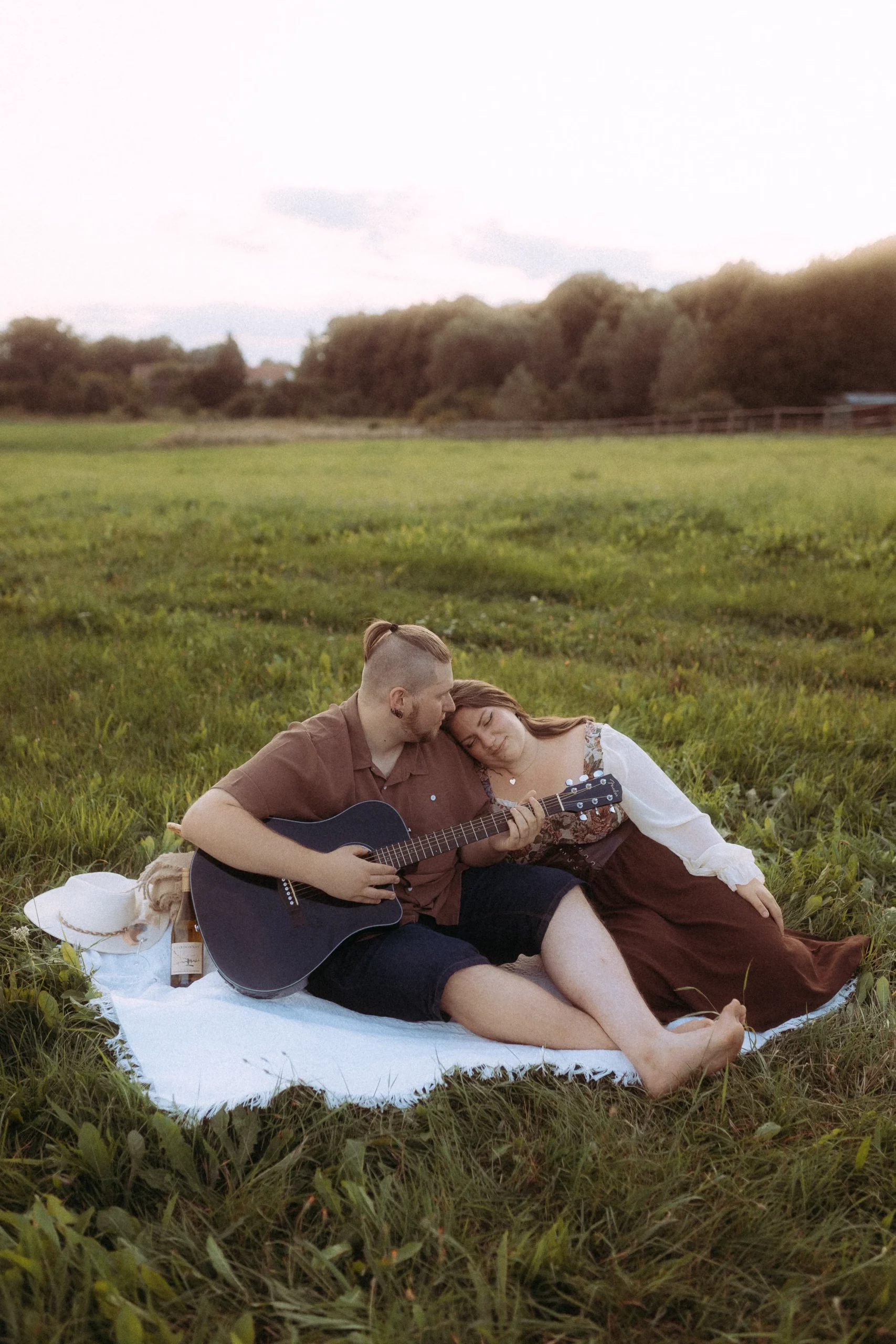 Paar spielt Gitarre im Grünen