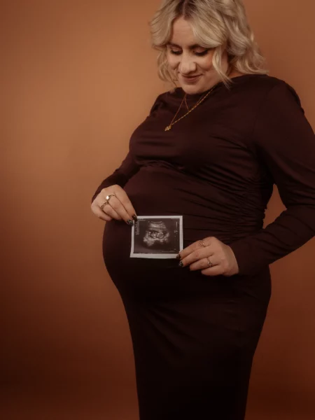 Schwangere Frau hält Ultraschallbild.