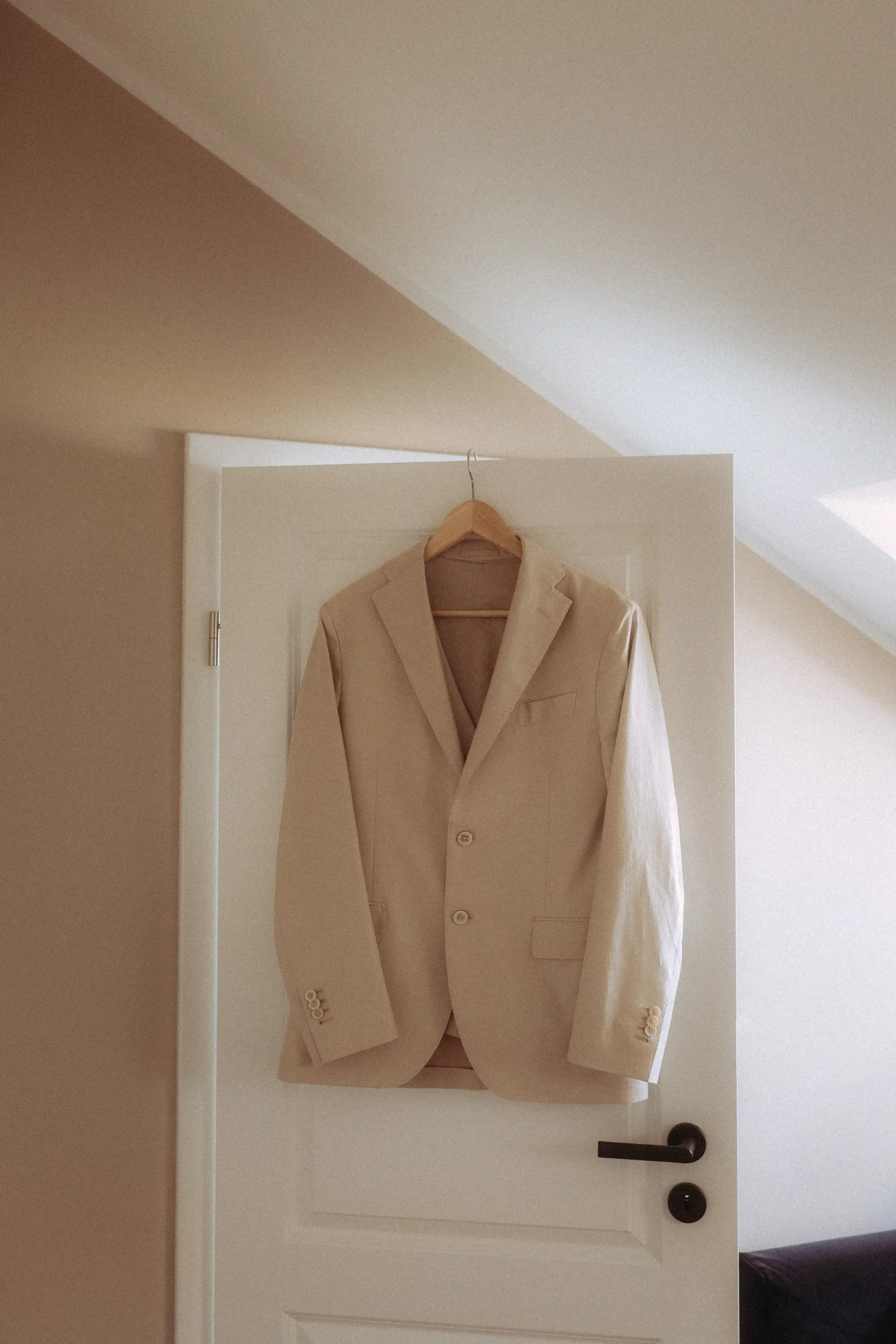 Beiger Blazer hängt an Tür