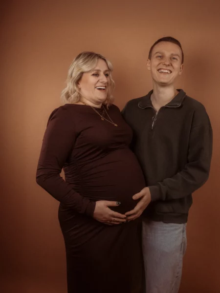 Schwangere Frau mit Partner lächelt