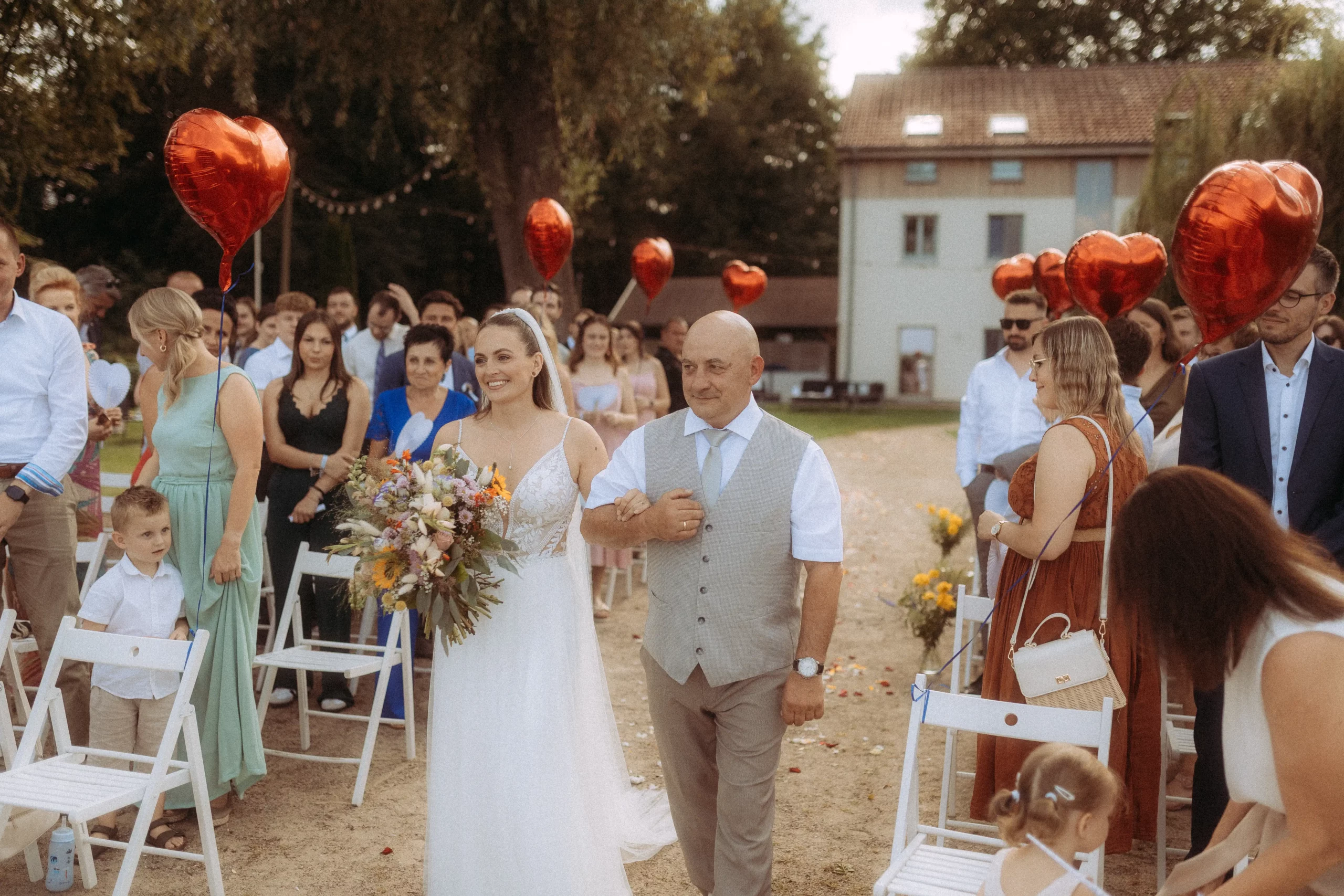 Braut mit Vater schreitet zum Altar.