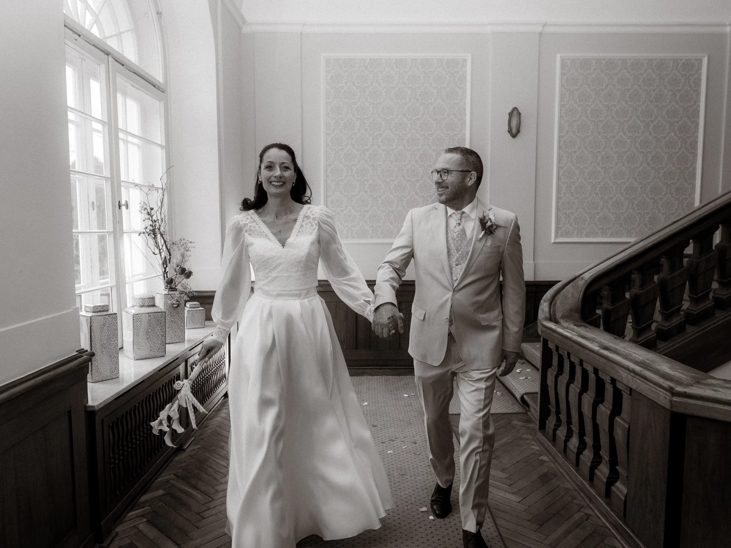 Brautpaar glücklich Händchen haltend auf dem Weg nach der Hochzeit. Hochzeitsfotograf in Deutschland.