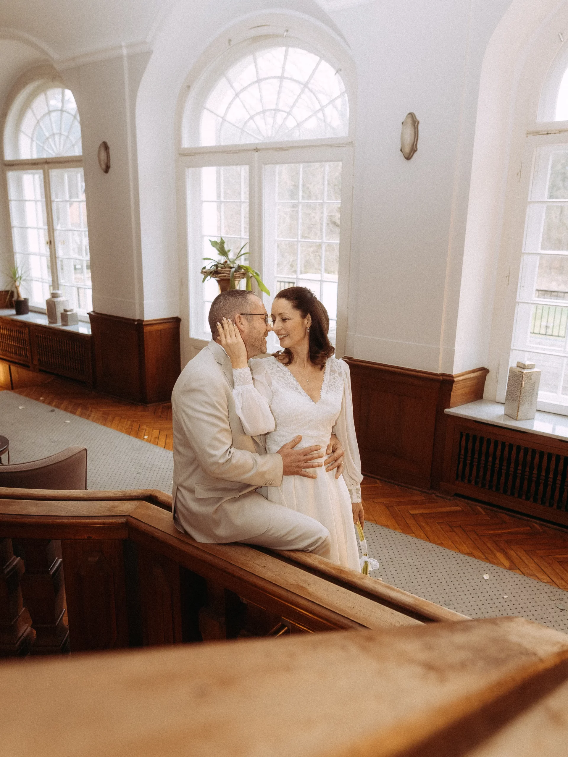 Brautpaar umarmt sich liebevoll auf Treppe. Hochzeitsfotograf in Berlin.