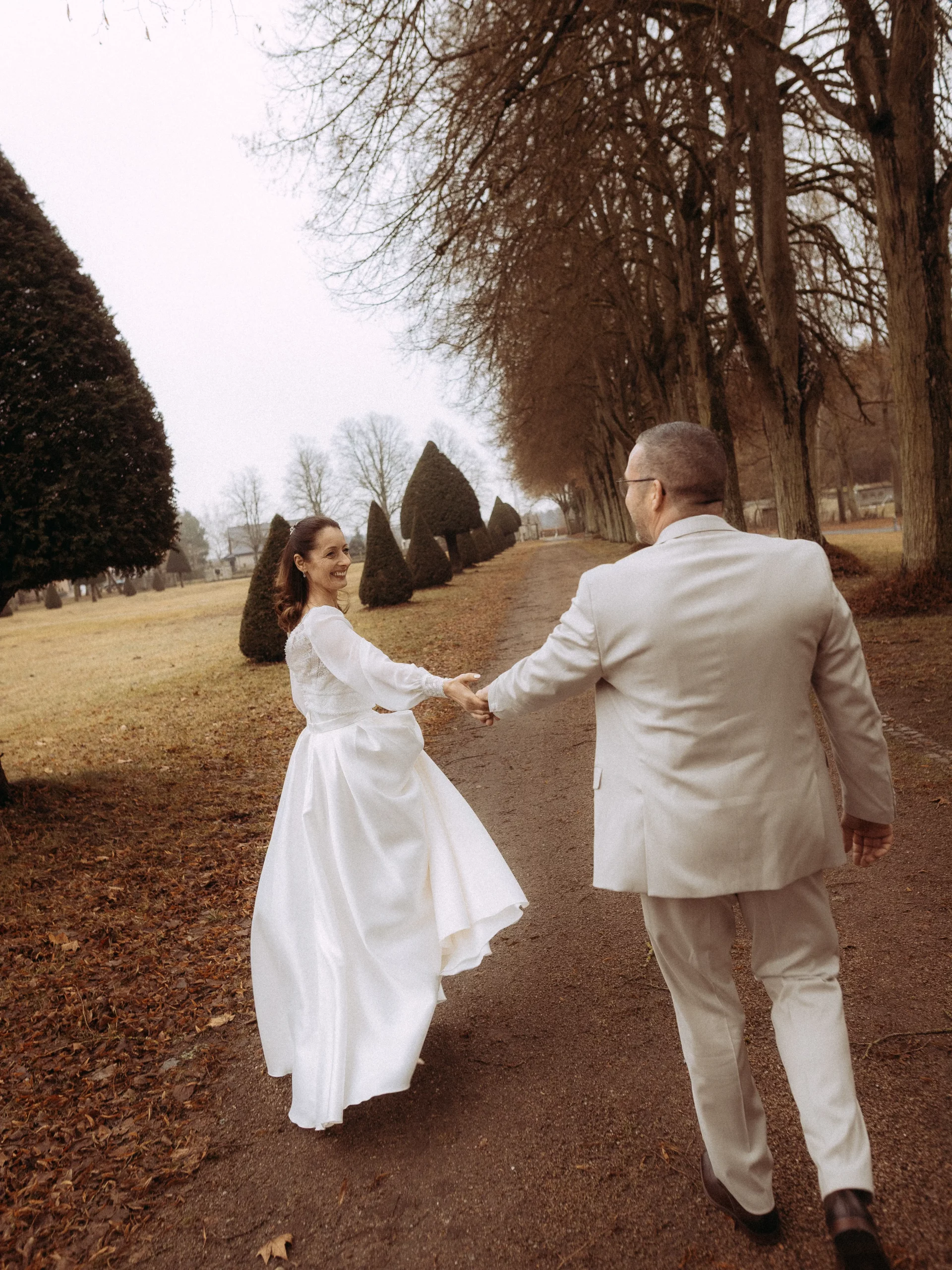 Brautpaar Hand in Hand auf einem Weg in Deutschland. Hochzeitsfotograf in Deutschland.