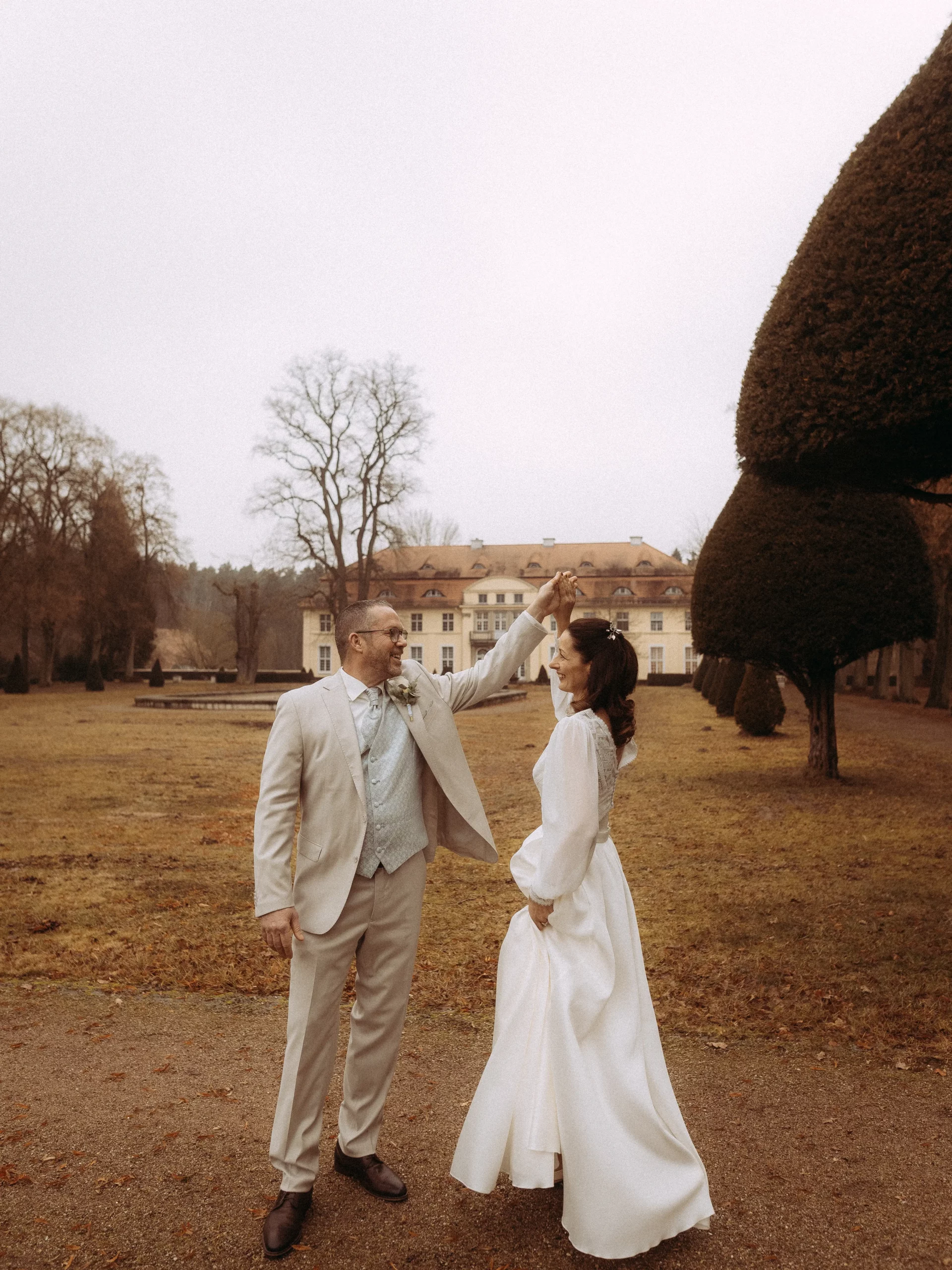 Brautpaar tanzt vor Schloss. Hochzeitsfotograf in unbekannter Stadt.
